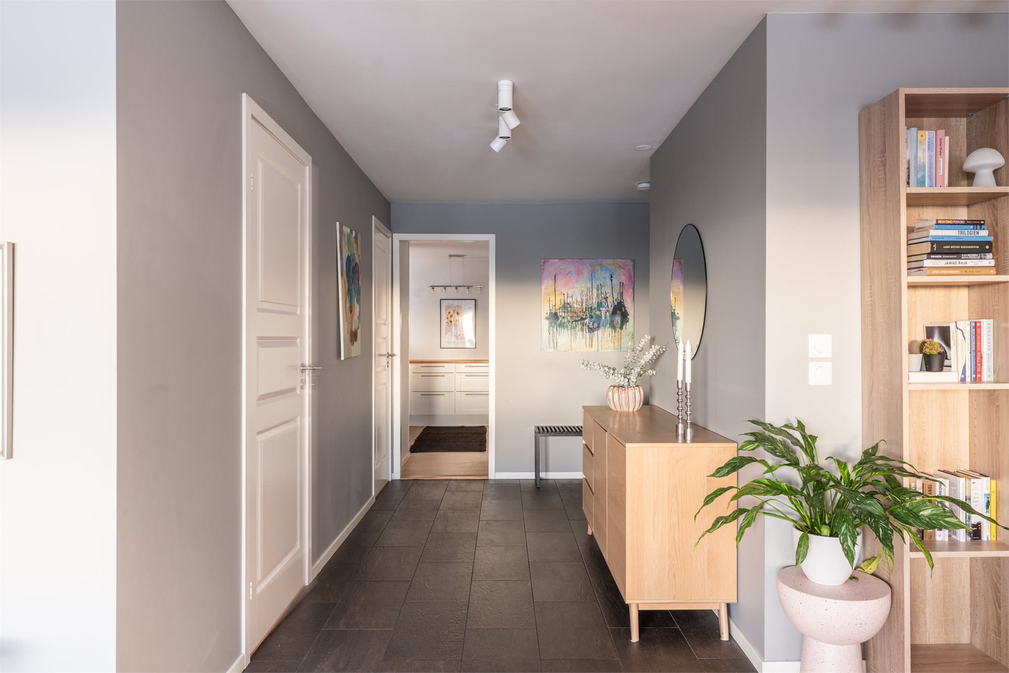 Fra entreen åpner leiligheten seg opp, med en gang som leder videre inn mot oppholdsrommene.