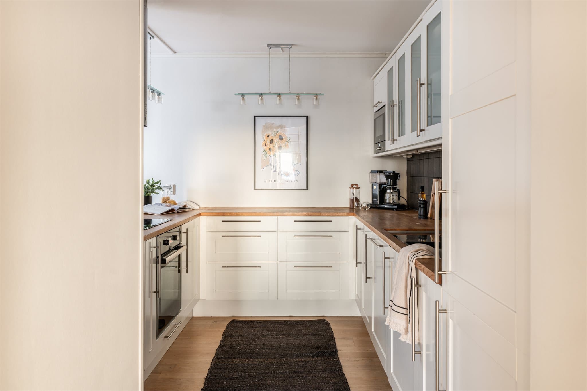 Kjøkkenet har en praktisk U-form som gir rikelig med benke- og skapplass.