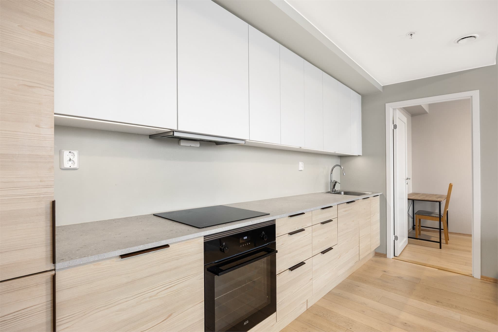 Moderne kjøkkeninnredning med glatte fronter, laminat benkeplate og kjøkkenkum.