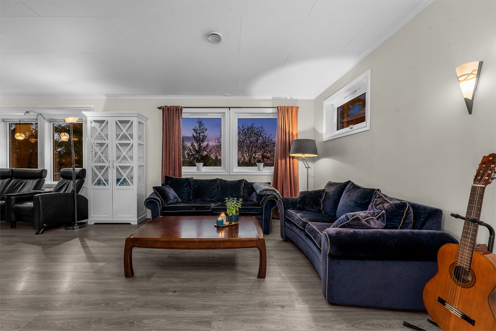 Kveldsstemning i stuen. Lysmalte flater gjør innredningen enkel.