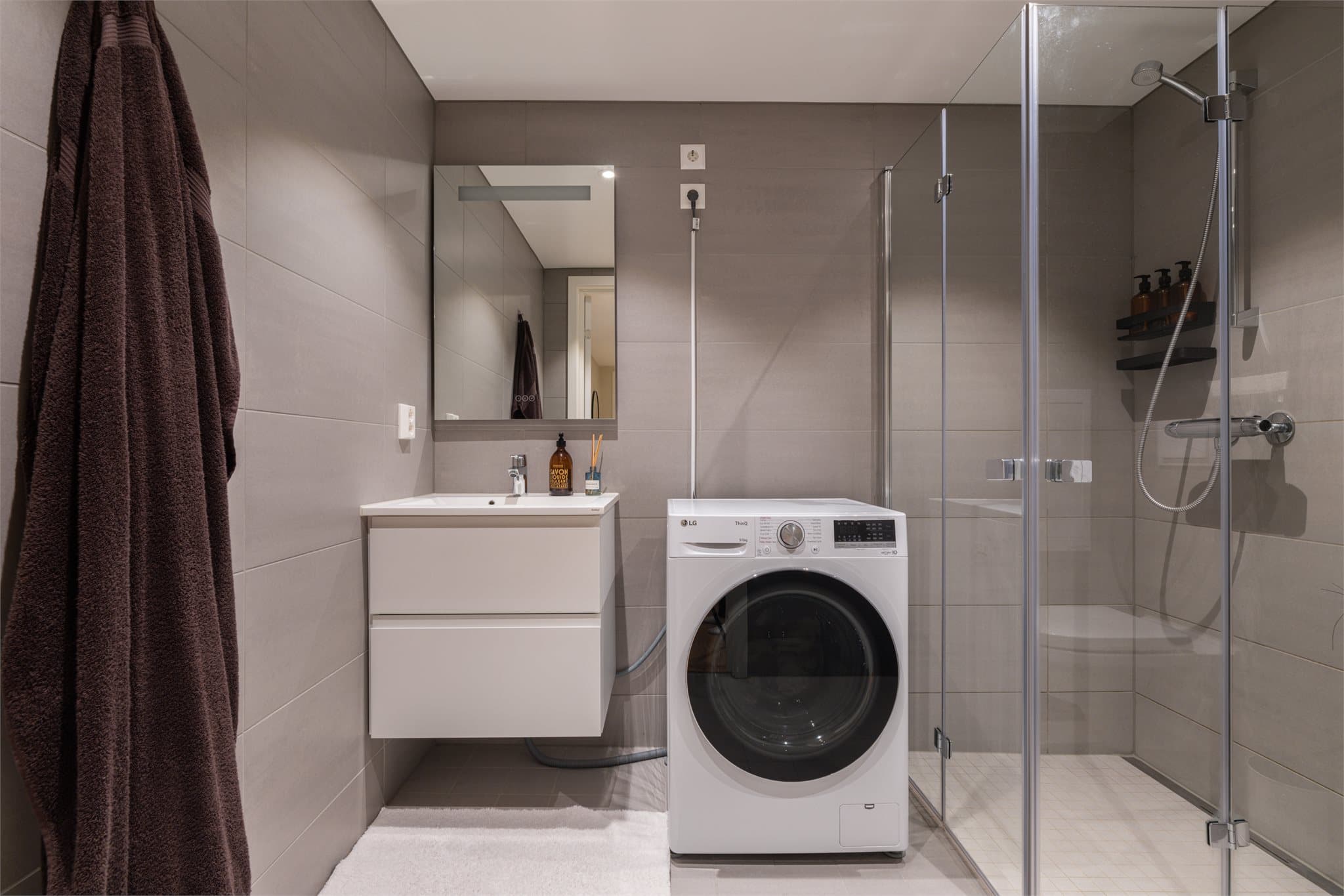 Her er det innfellbare dusjvegger i glass og et vegghengt toalett.