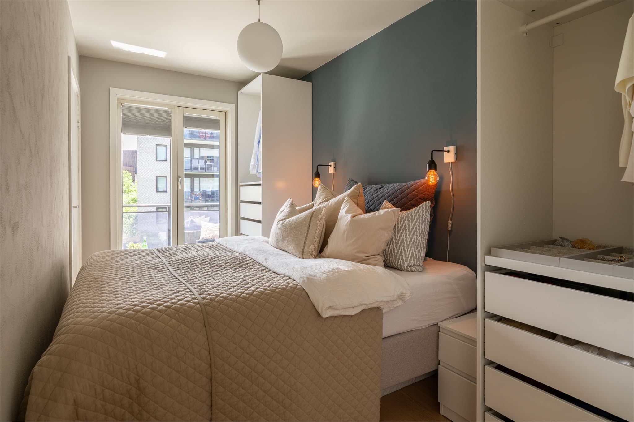 Leilighetens soverom har en god størrelse med plass til dobbeltseng og nattbord.