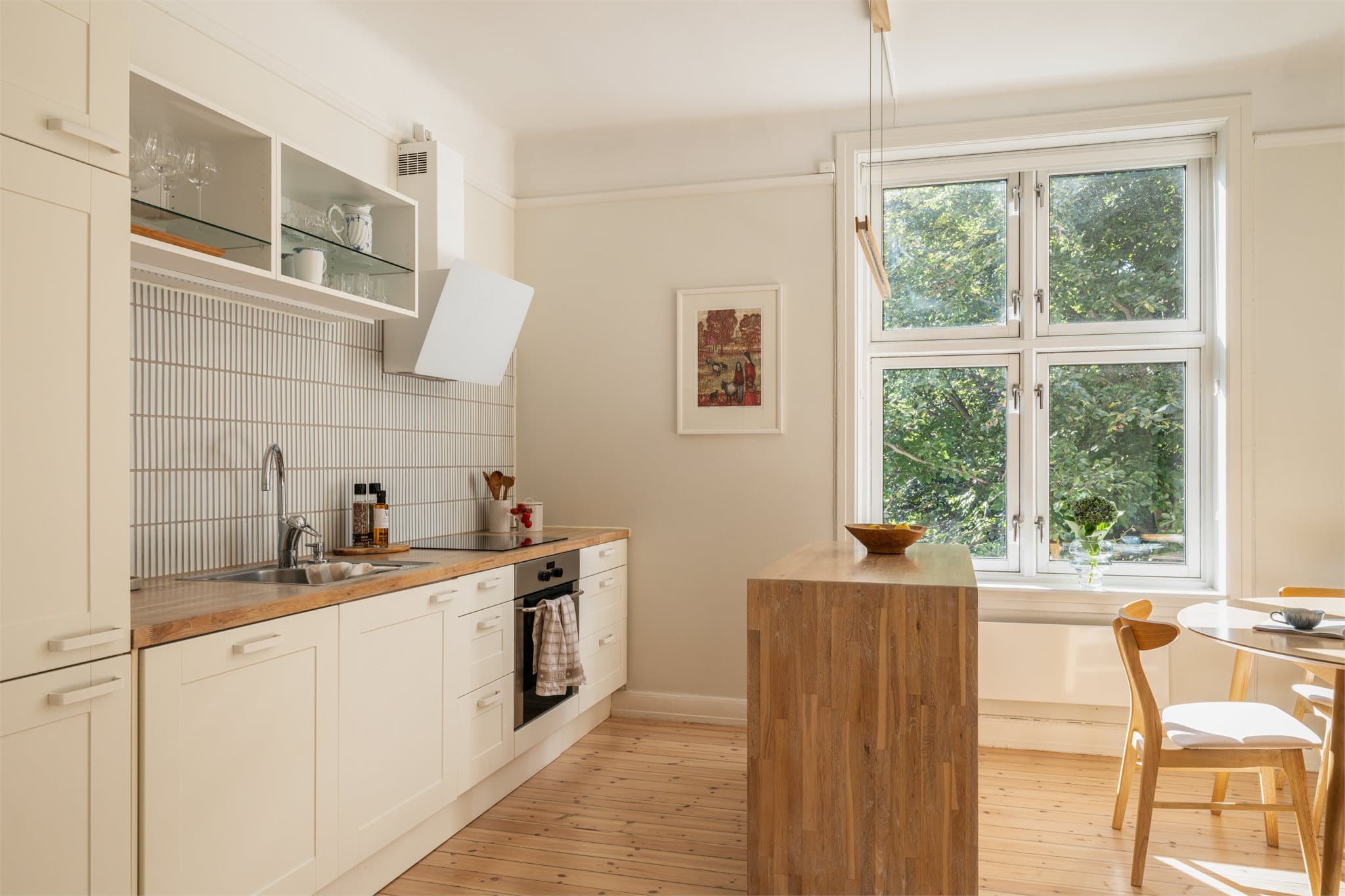 En kjøkkenøy deler rommet fint opp i to soner, en for matlaging og en for spisebord hvor du enkelt kan servere gjestene.