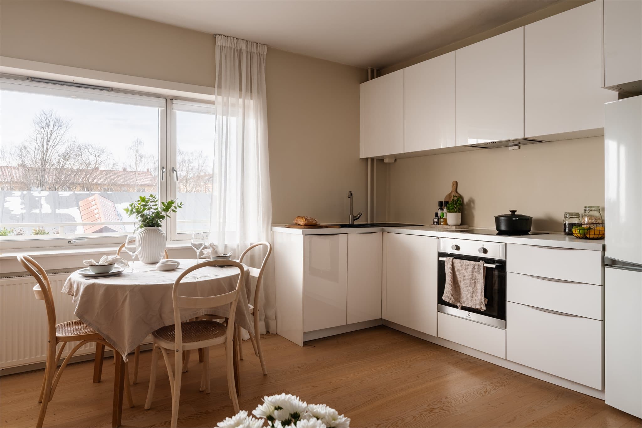 Kjøkkeninnredning fra 2014 med glatte, hvite fronter og benkeplate i laminat.