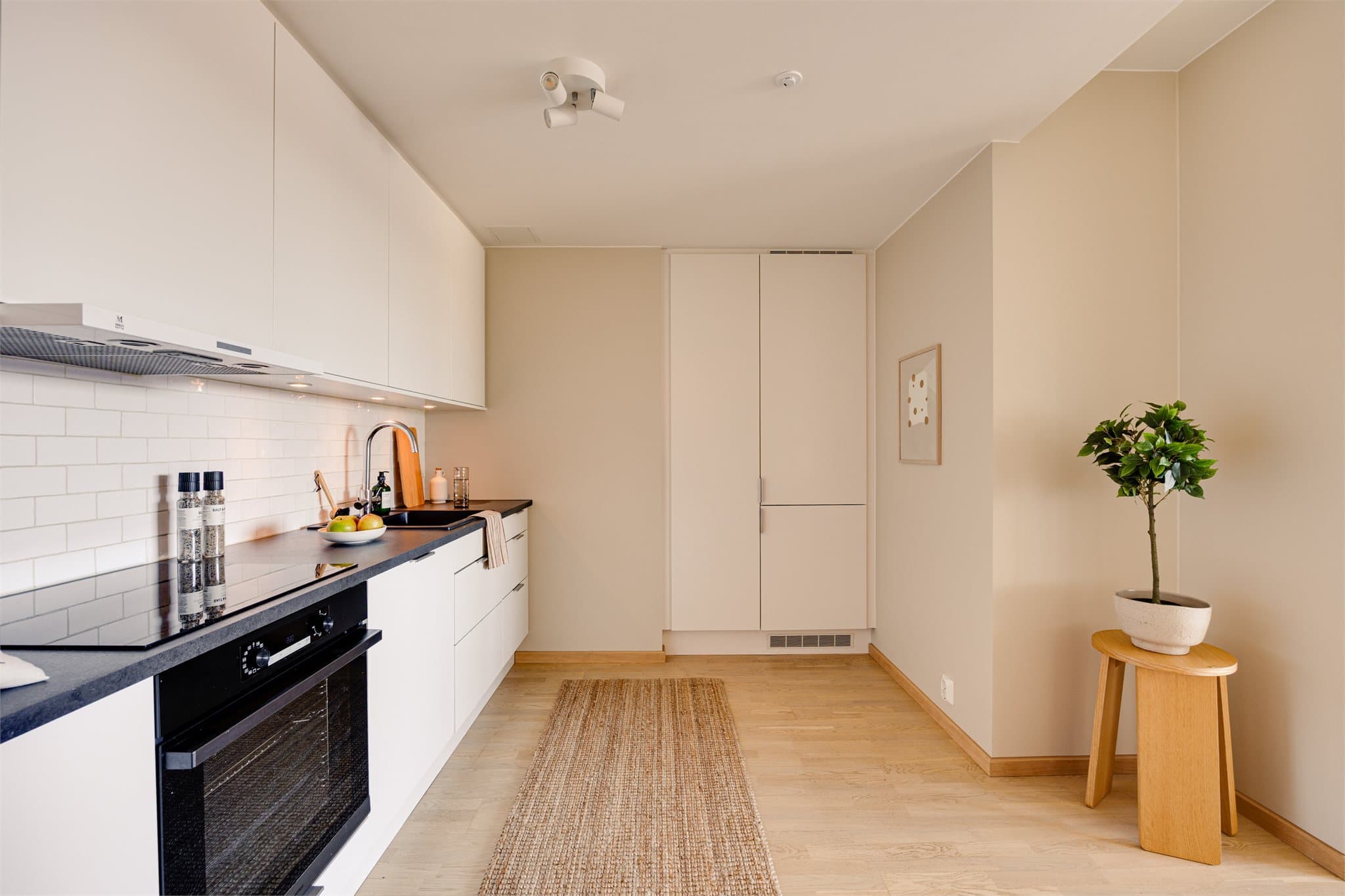 Klassisk og pent kjøkken med slette fronter og integrerte hvitevarer.