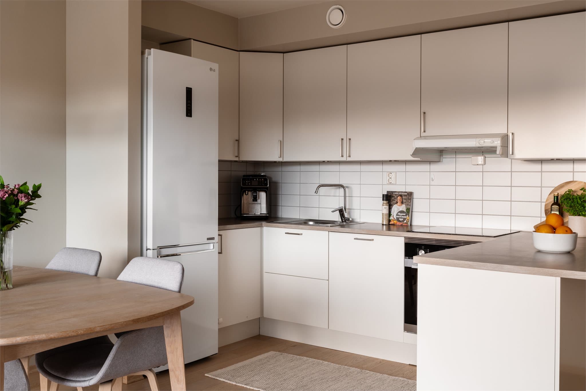 Lyst, tidløst kjøkken med god kombinasjon av skap- og benkeplass.