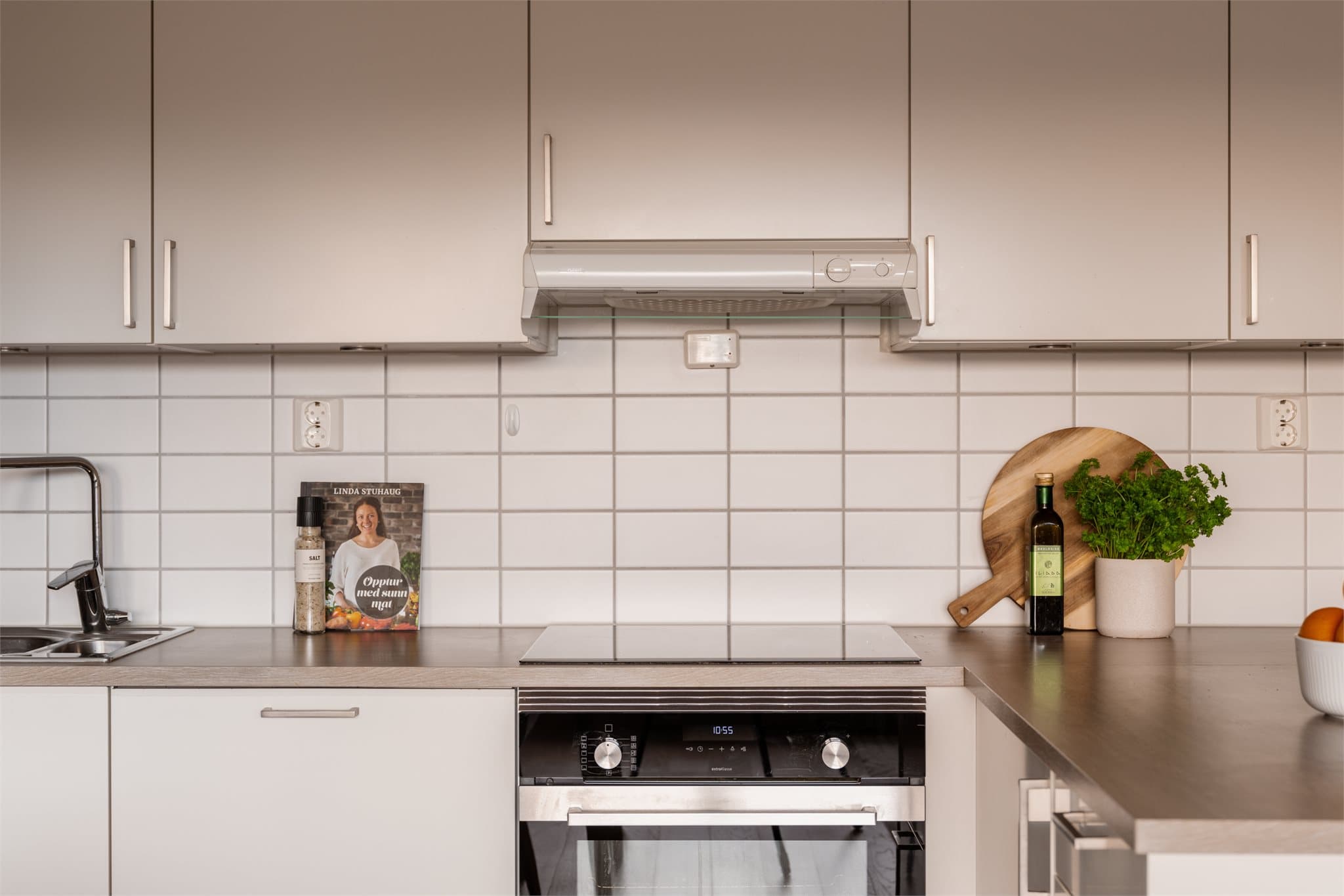 Det er integrert stekeovn og induksjonstopp, som gir et moderne og funksjonelt preg.