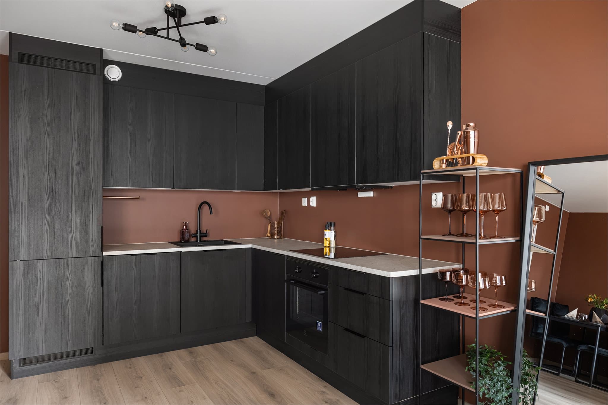 Leilighetens sosiale sone har et stilrent HTH-kjøkken fra 2024 med integrerte hvitevarer og god arbeidsplass.