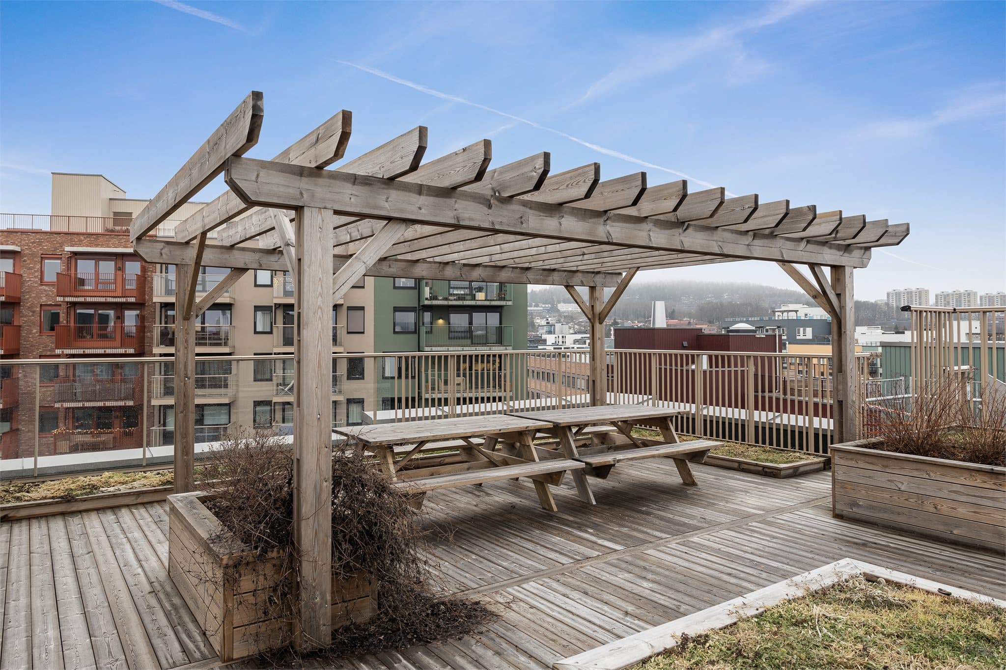 En pergola med sittebenker gir en lun og hyggelig sone på takterrassen.