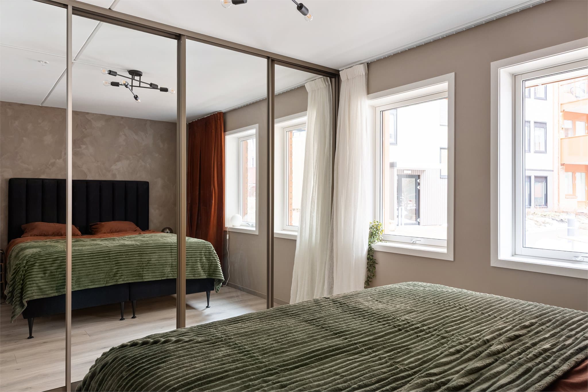 En spesialtilpasset garderobeløsning med speilfronter gir rikelig med oppbevaringsplass og en god romfølelse.