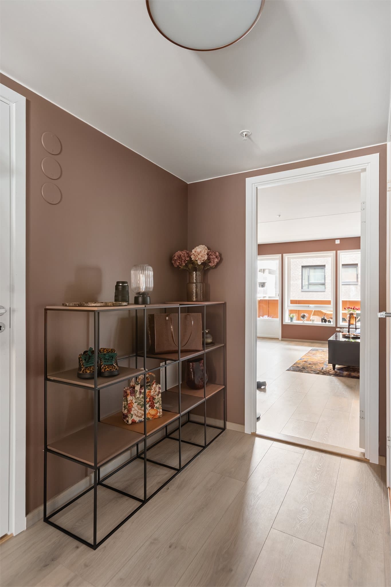 Gjennomgående laminatgulv og glattmalte vegger gir et helhetlig og moderne uttrykk fra første steg.