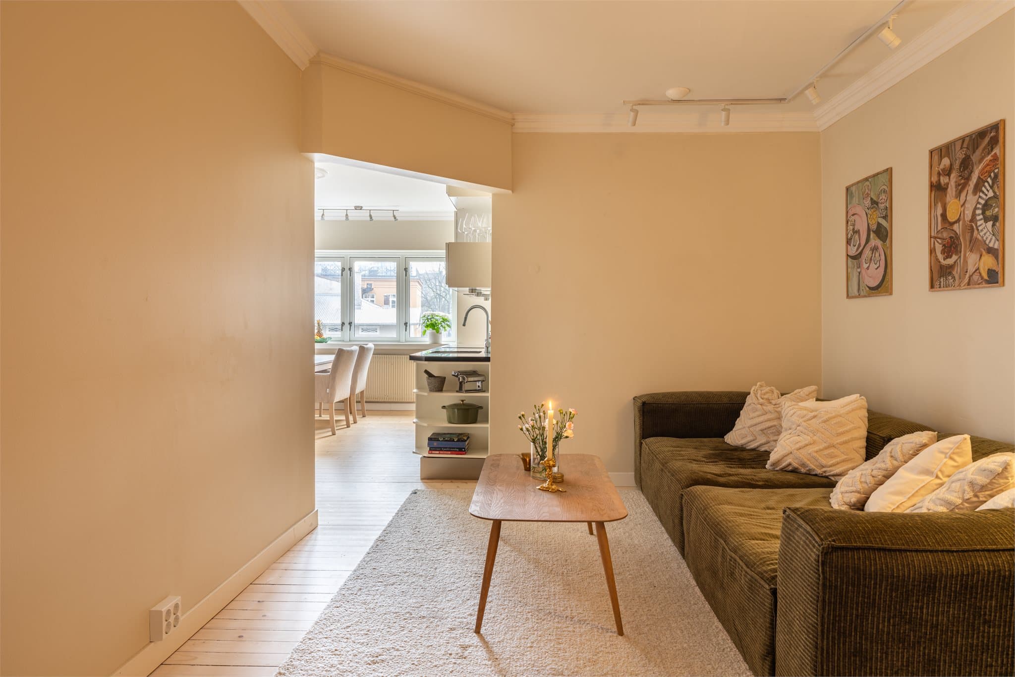 Den delvis åpne løsningen mellom stue og kjøkken gir en lys og sosial sone.