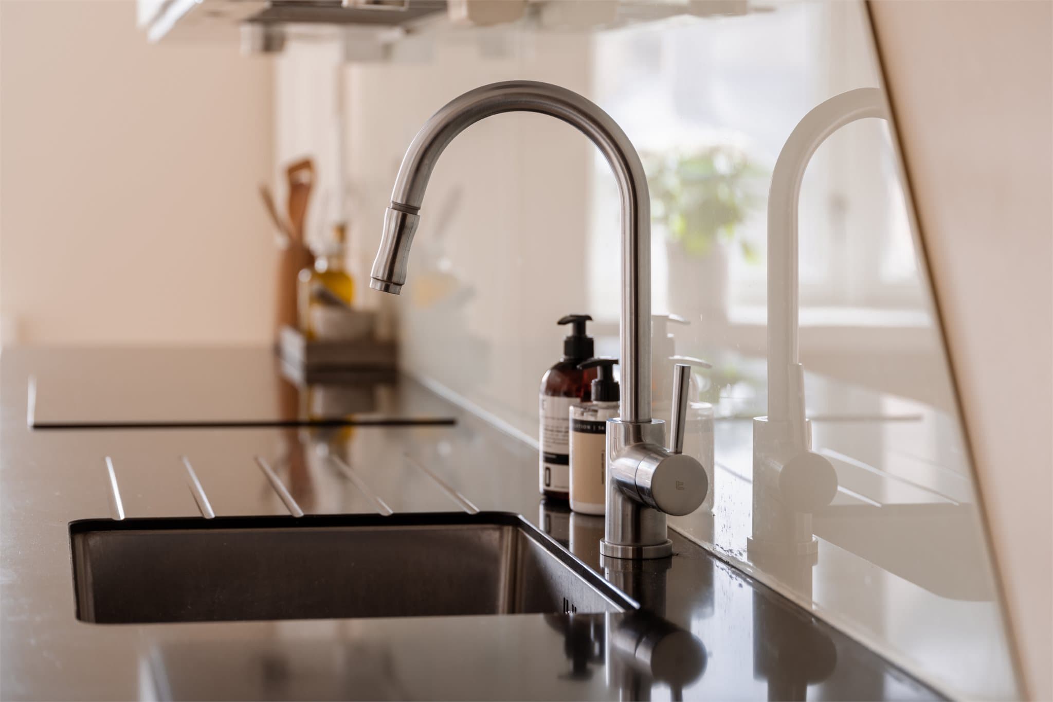 Benkeplaten i stein med nedfelt vask gir en funksjonell og slitesterk arbeidsflate.