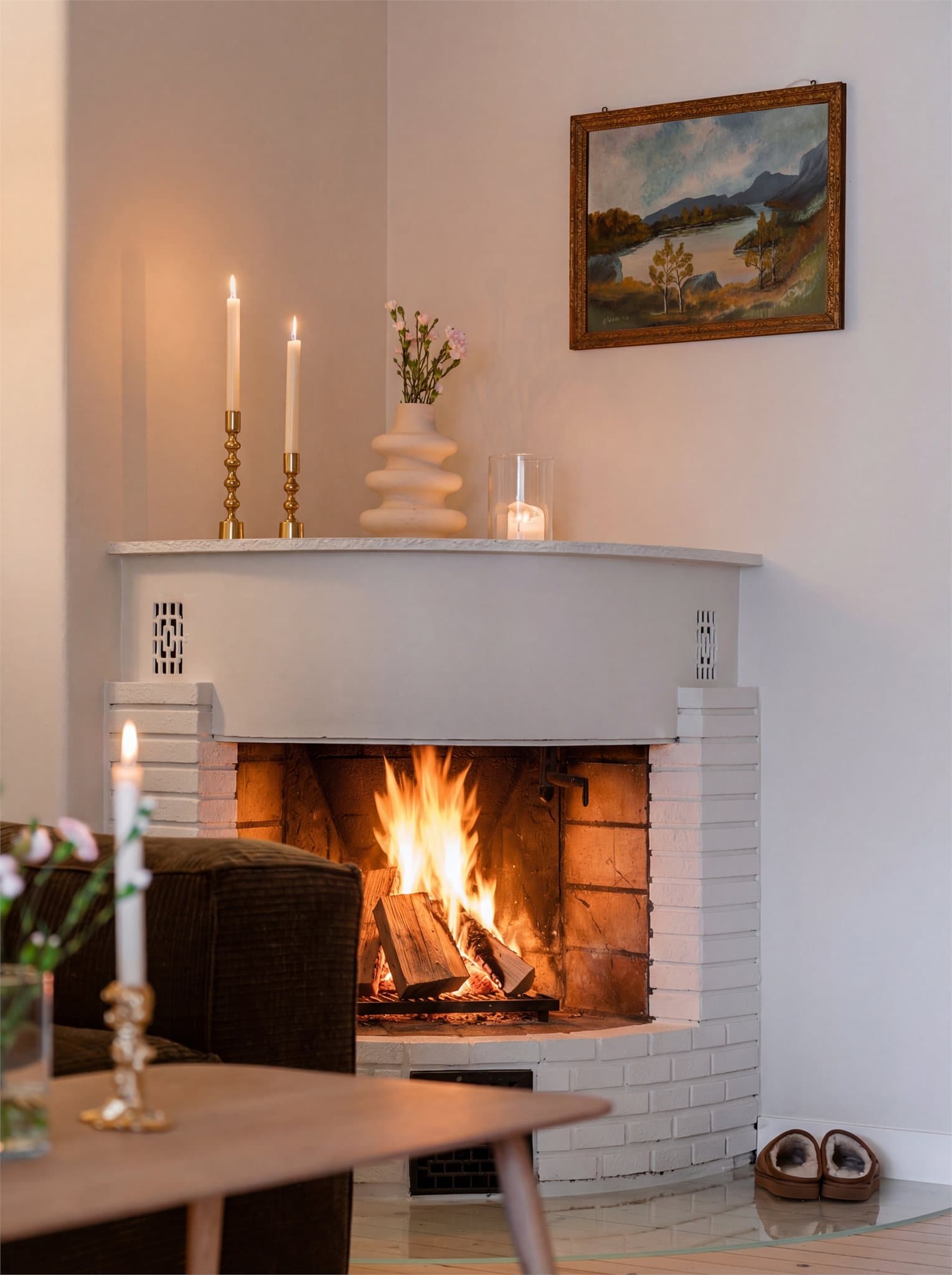 Mursteinspipen med vedovn er et sentralt og stemningsfullt element i stuen.