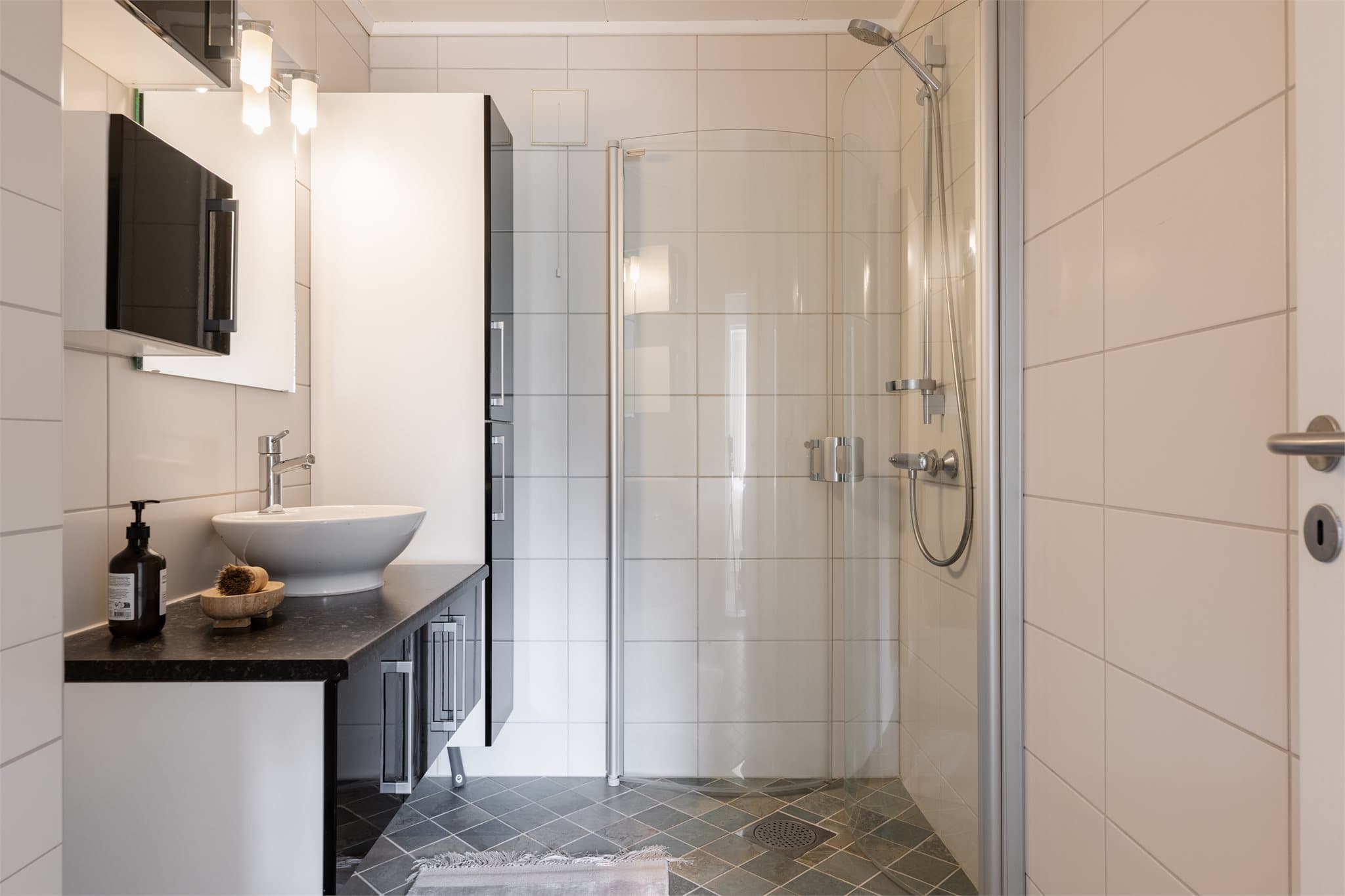 Badet har flislagte gulv og vegger, himlingsplater i tak og elektriske varmekabler i gulvet.