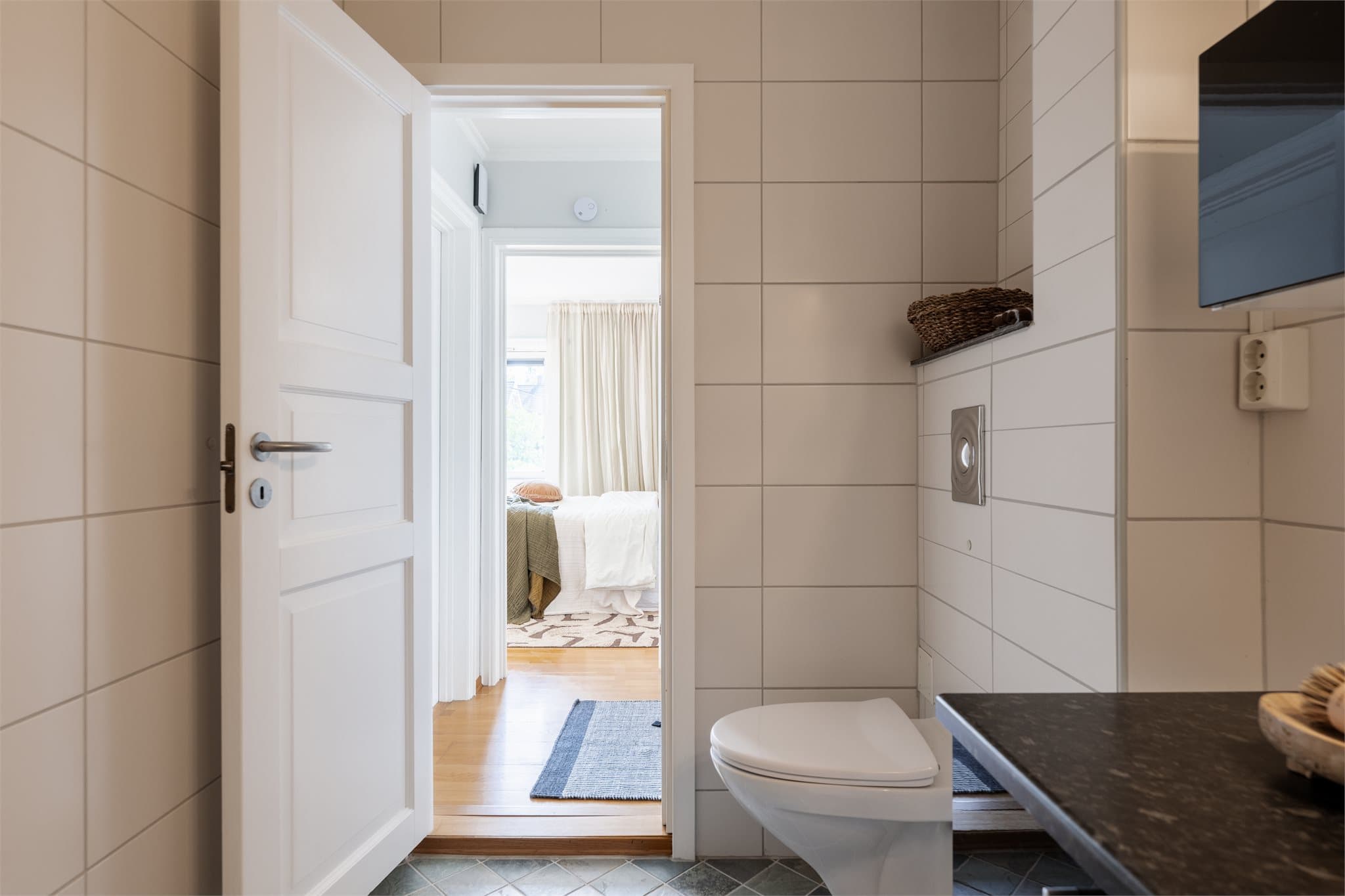 Badet er innredet med servant, toalett og dusjvegger/dusjhjørne.