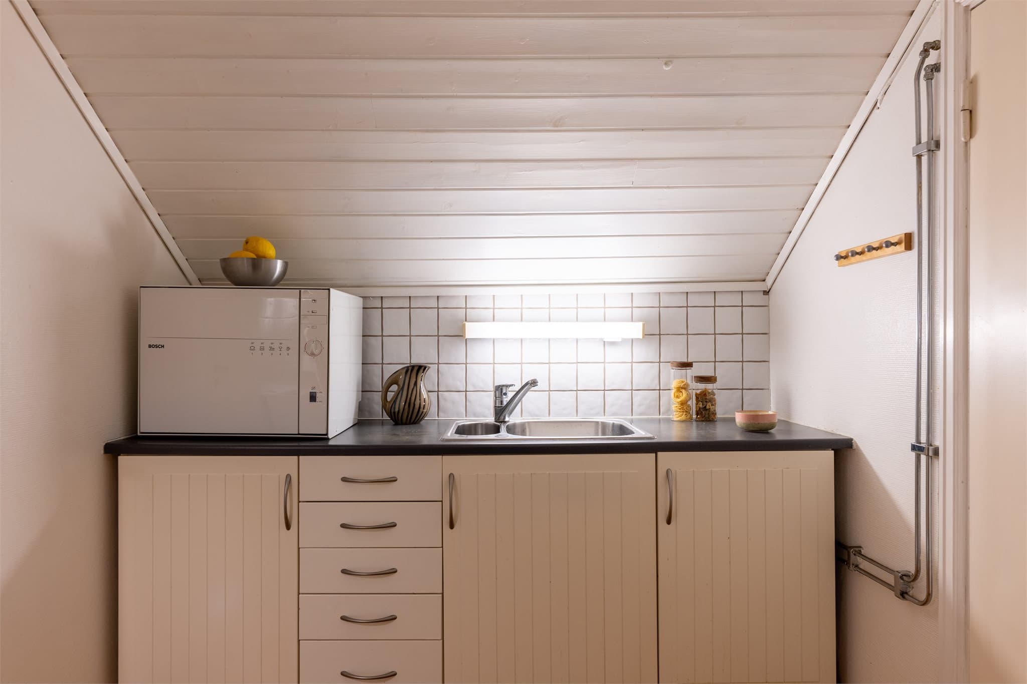 Kjøkkenet har innredning med profilerte fronter og laminatbenkeplate.