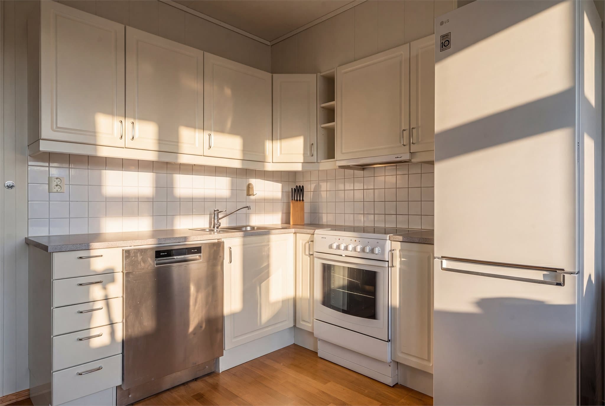 Innredningen har hvite, profilerte fronter og laminat benkeplate.