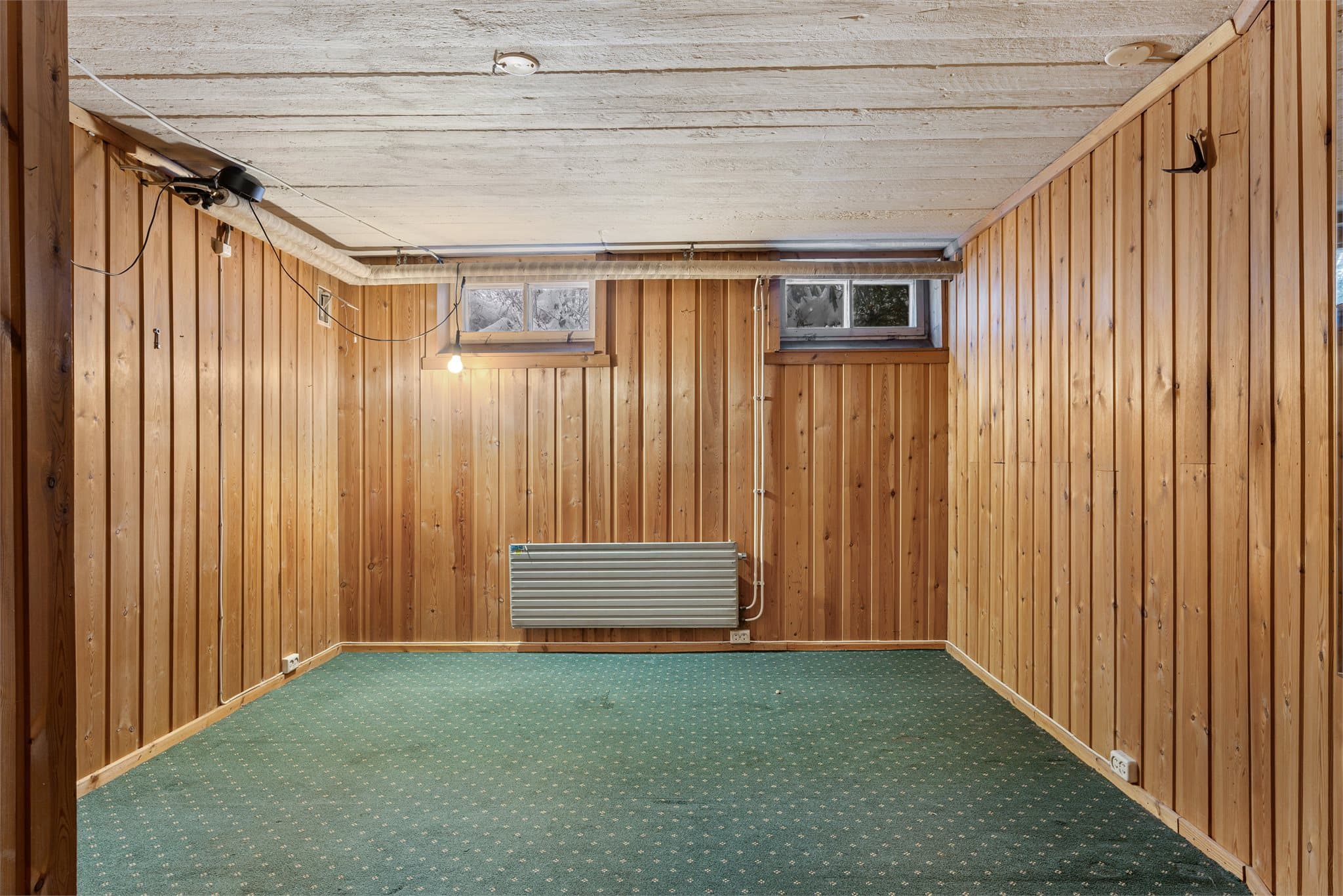 Rom med teppegulv og panelvegger. Rommet oppfyller ikke kravene til varig opphold grunnet rømningsvei.