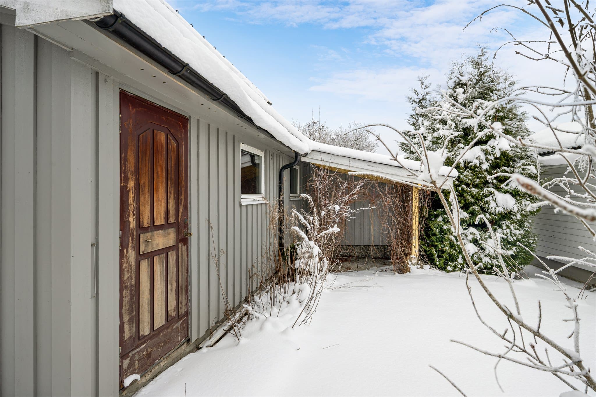 Boligen har en hellelagt uteplass med pergola.