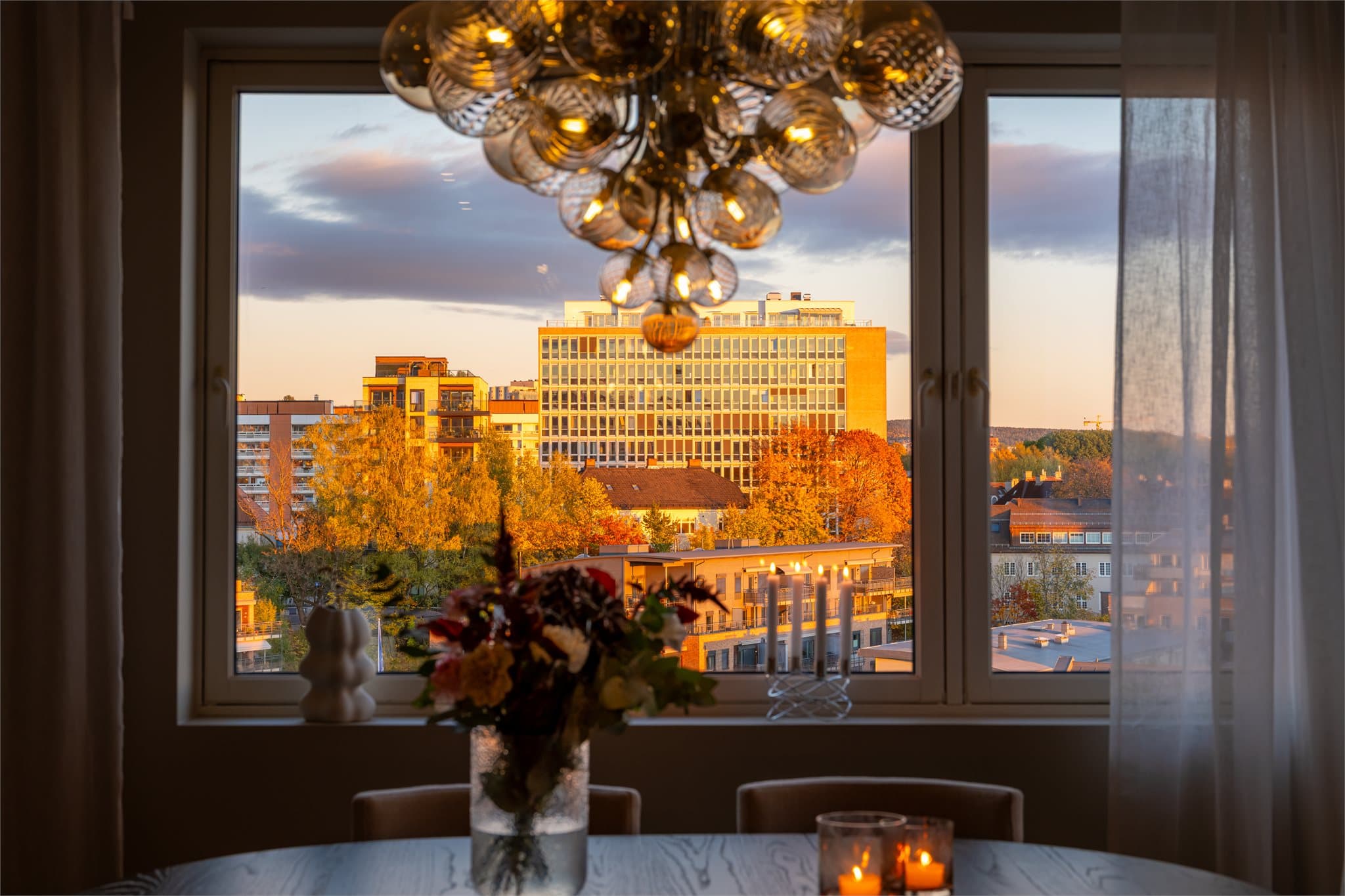 Hjørneleilighetens mange vinduer gir en flott ramme rundt utsikten, også på kveldstid.