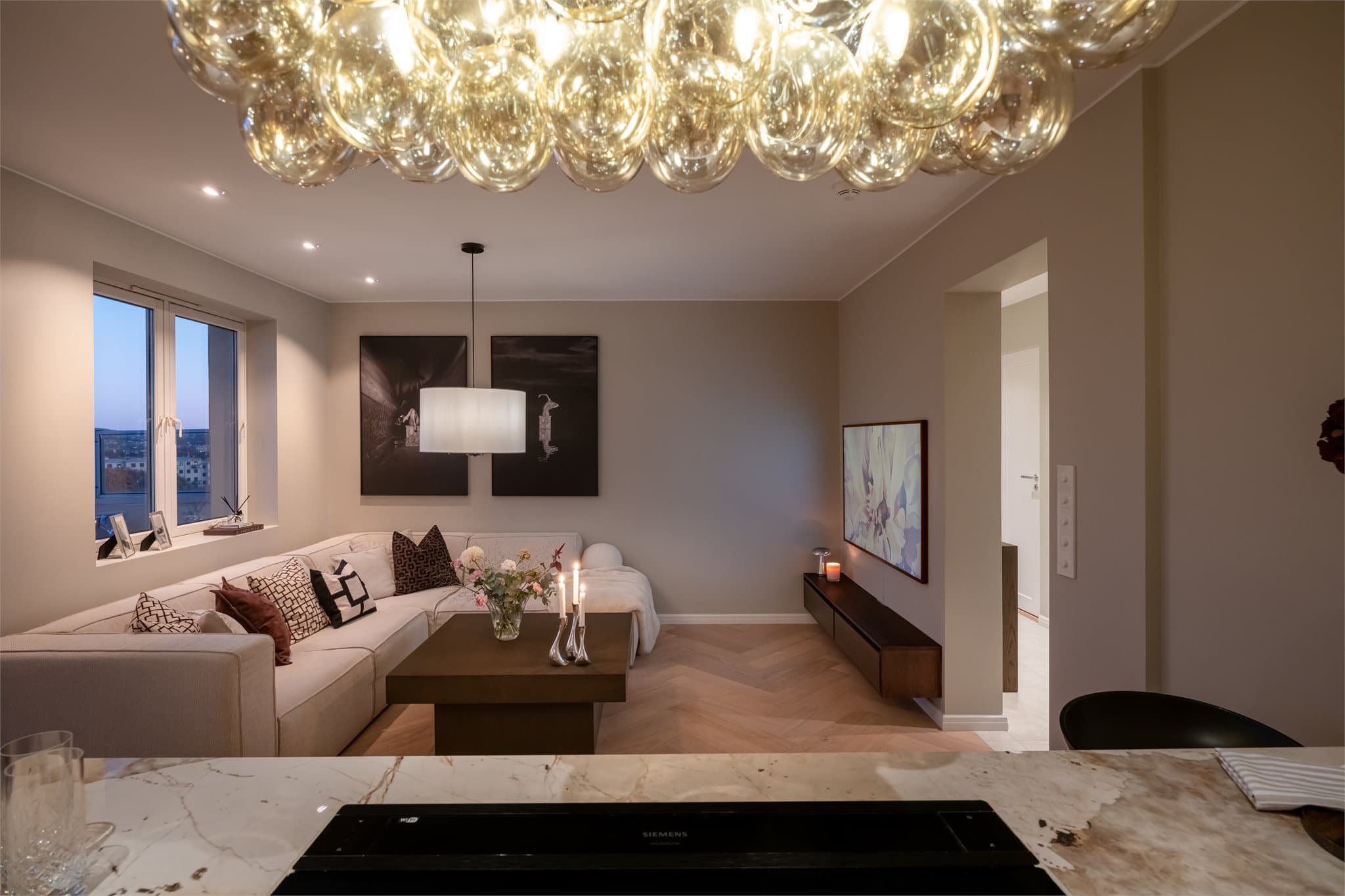 Fra kjøkkenøya har man full oversikt over stuen, noe som inviterer til sosial matlaging.