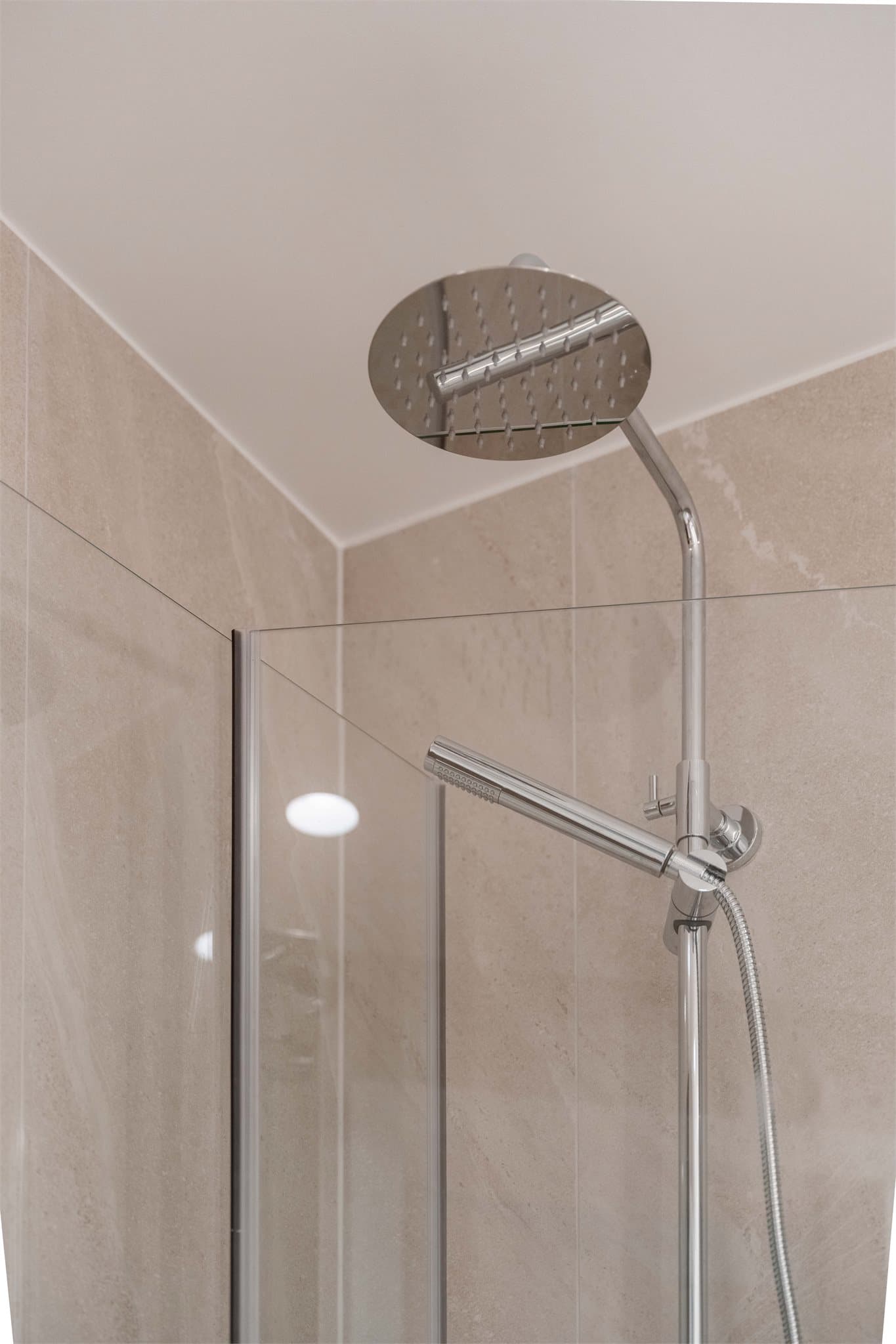 Dusjen har et moderne armatur med både takdusj og hånddusj for ekstra komfort.