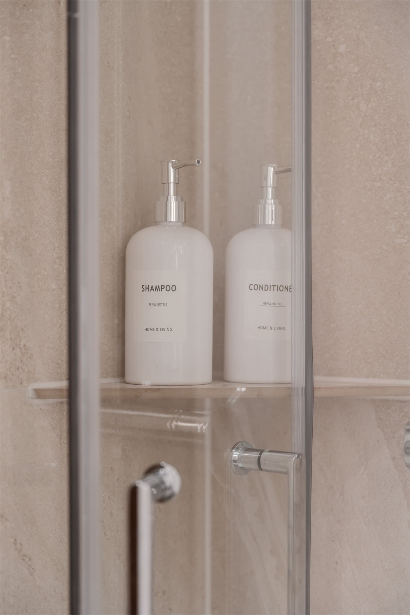 Dusjhjørnet har svingbare glassdører og en praktisk hylle til oppbevaring.