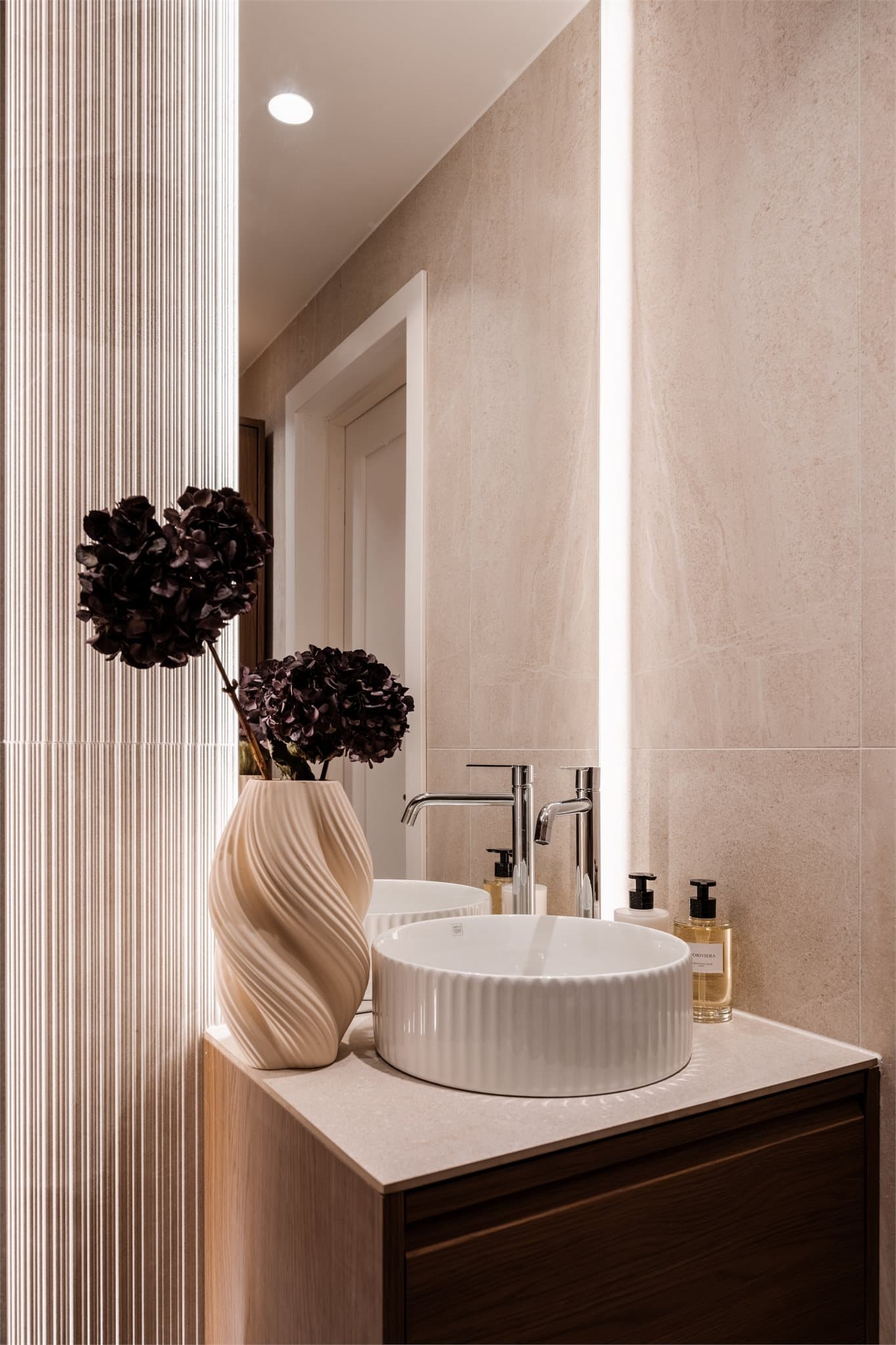 Elegant servant på en mørk innredning og et speil med integrert belysning.