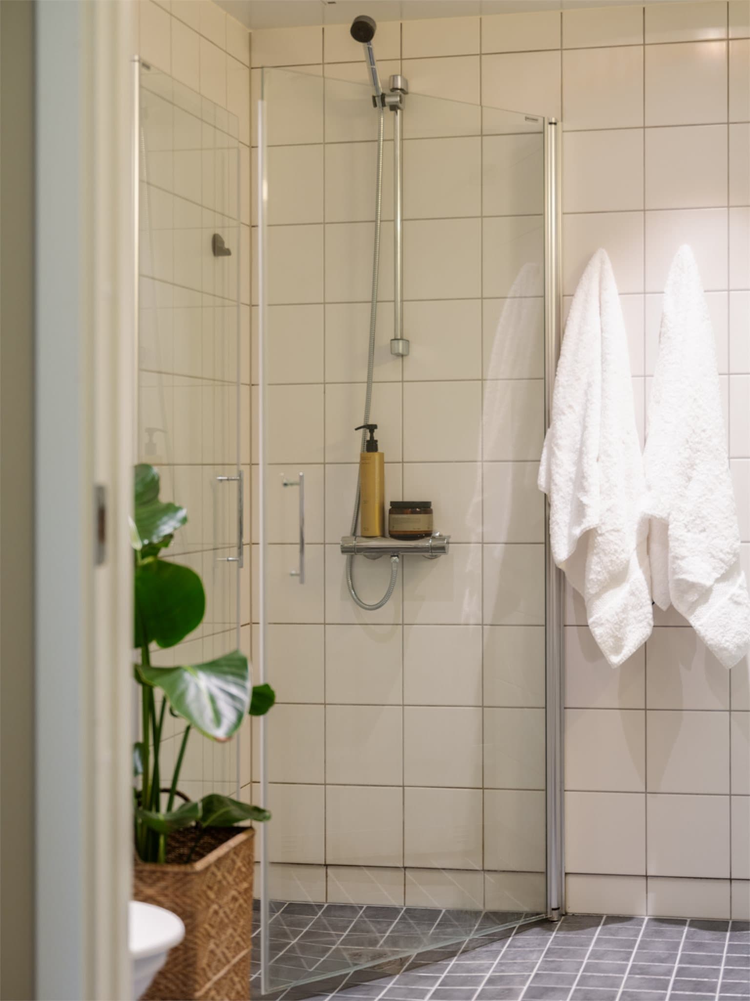 Dusjplass bak innfellbare dører i herdet glass.