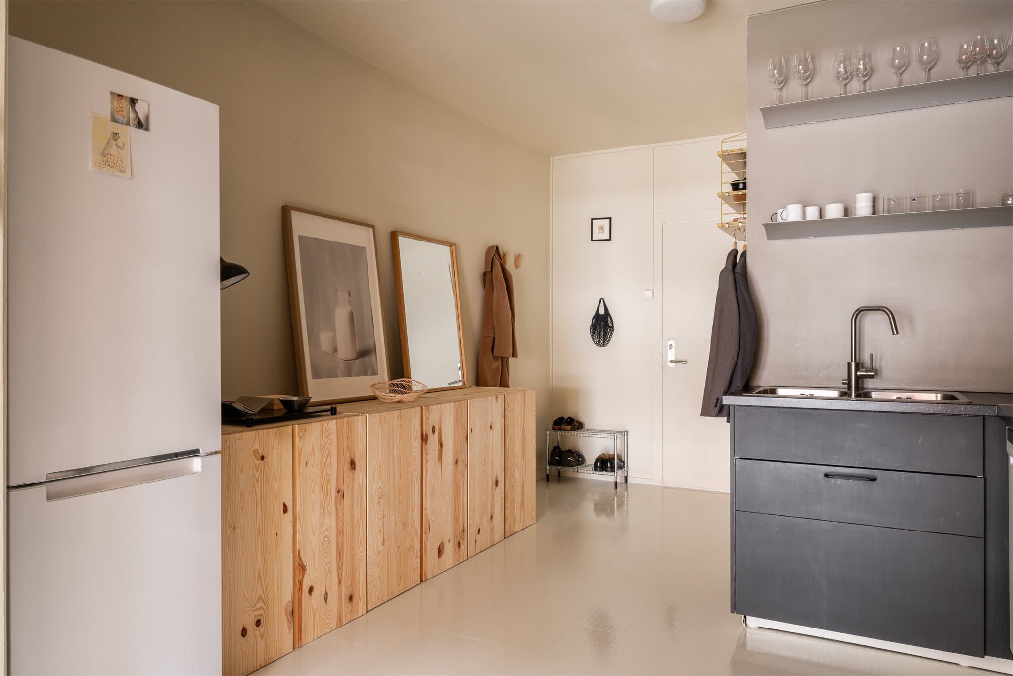 Kjøkkenet er utstyrt med opplegg for oppvaskmaskin, platetopp, stekeovn og kjøl/fryseskap. Over stekesonen er det montert kullfilterventilator, og de malte veggflatene gir et rent og tidløst uttrykk.