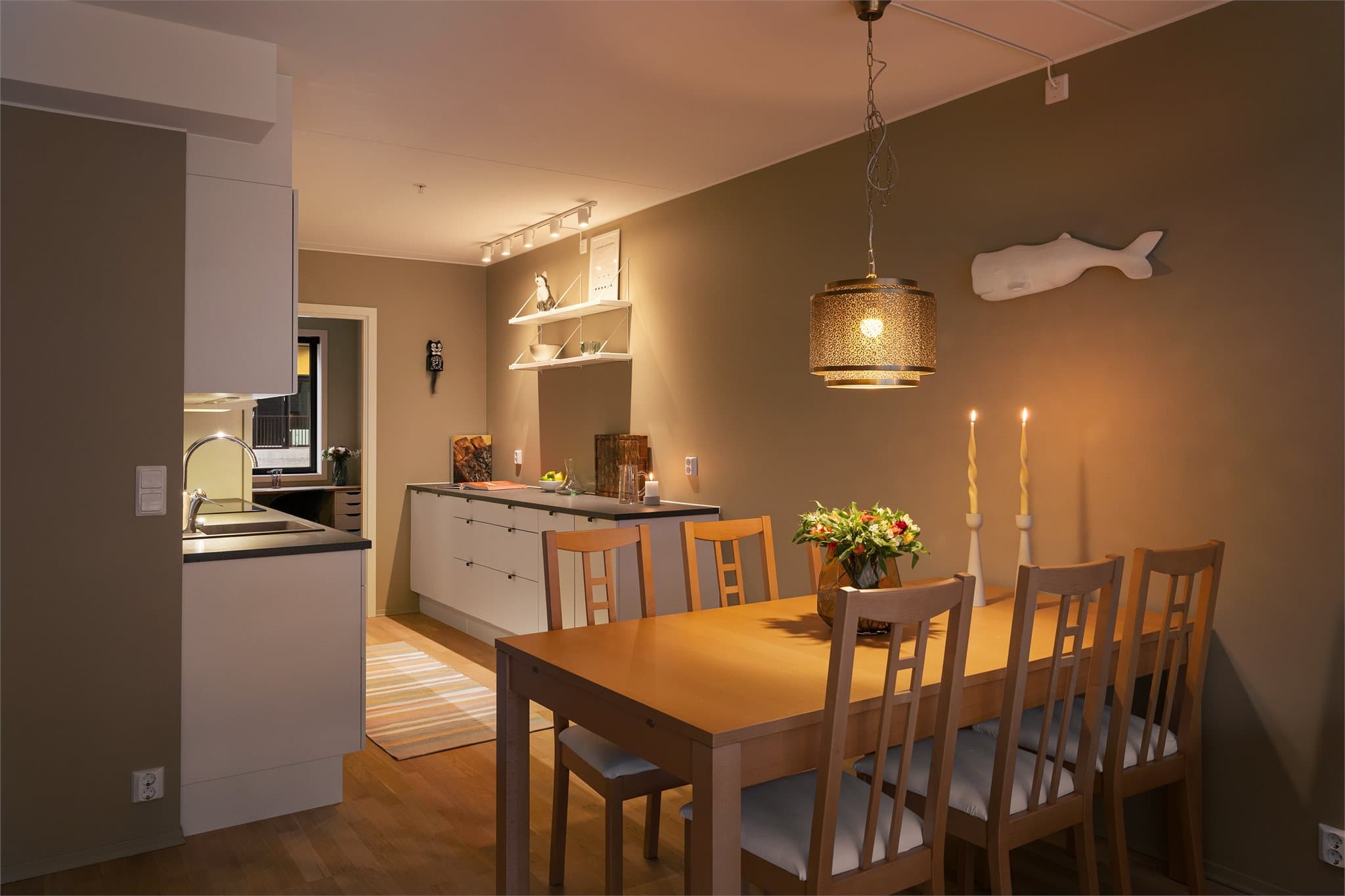 Den åpne løsningen mellom stue og kjøkken skaper en sosial og luftig atmosfære.