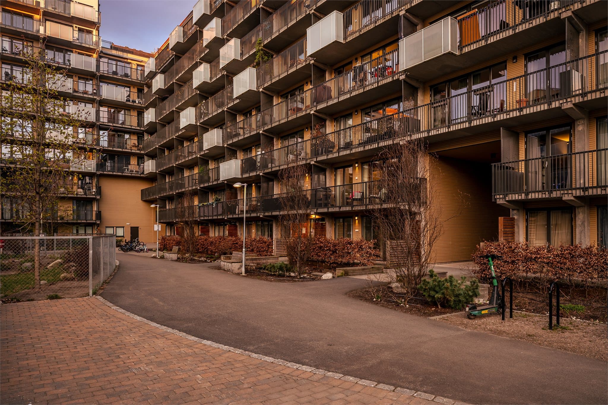 Hyggelige og bilfrie fellesarealer med gangstier og beplantning mellom bygningene.