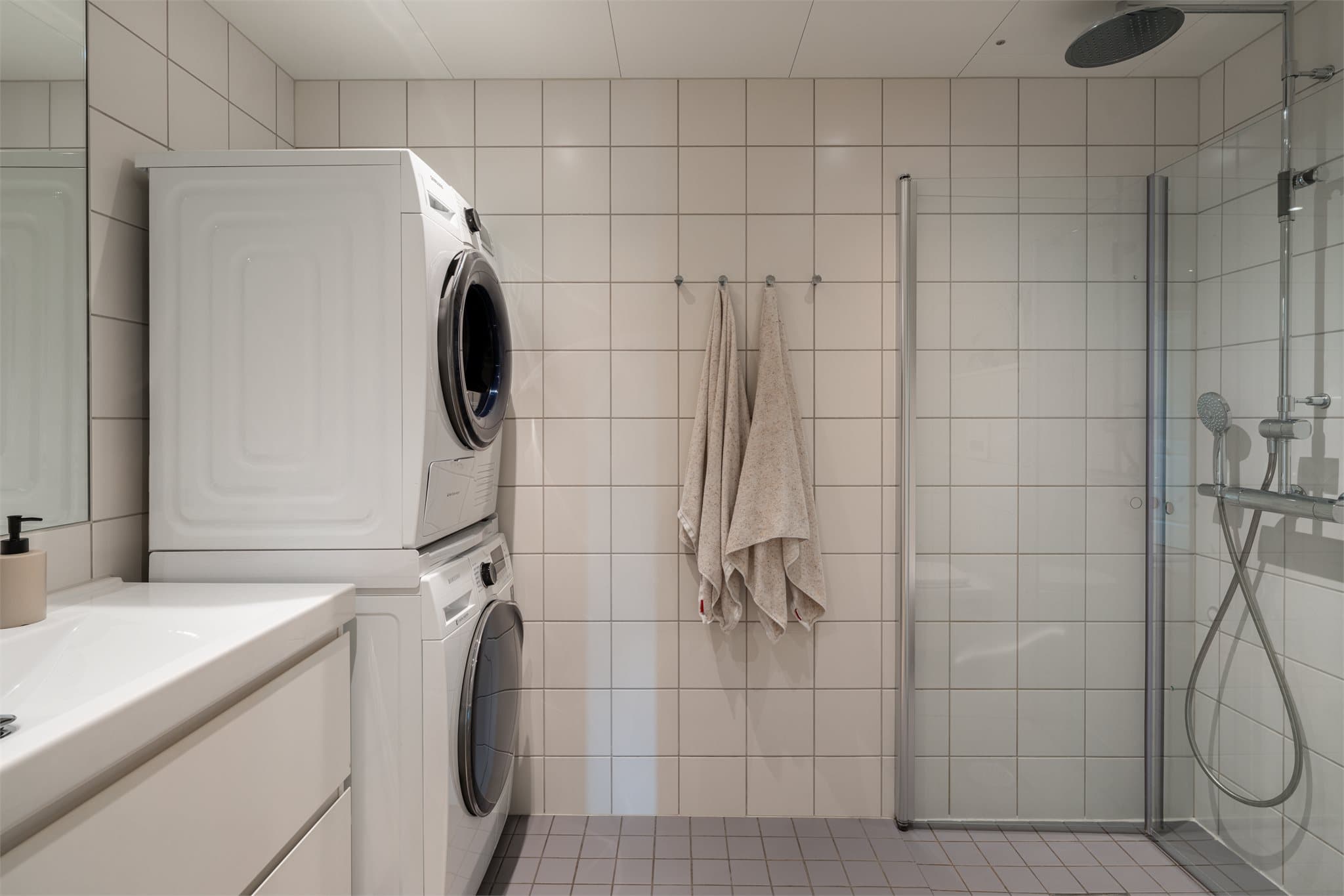 Badet har flislagte vegger, flislagt gulv med elektriske varmekabler og panelplater i taket.