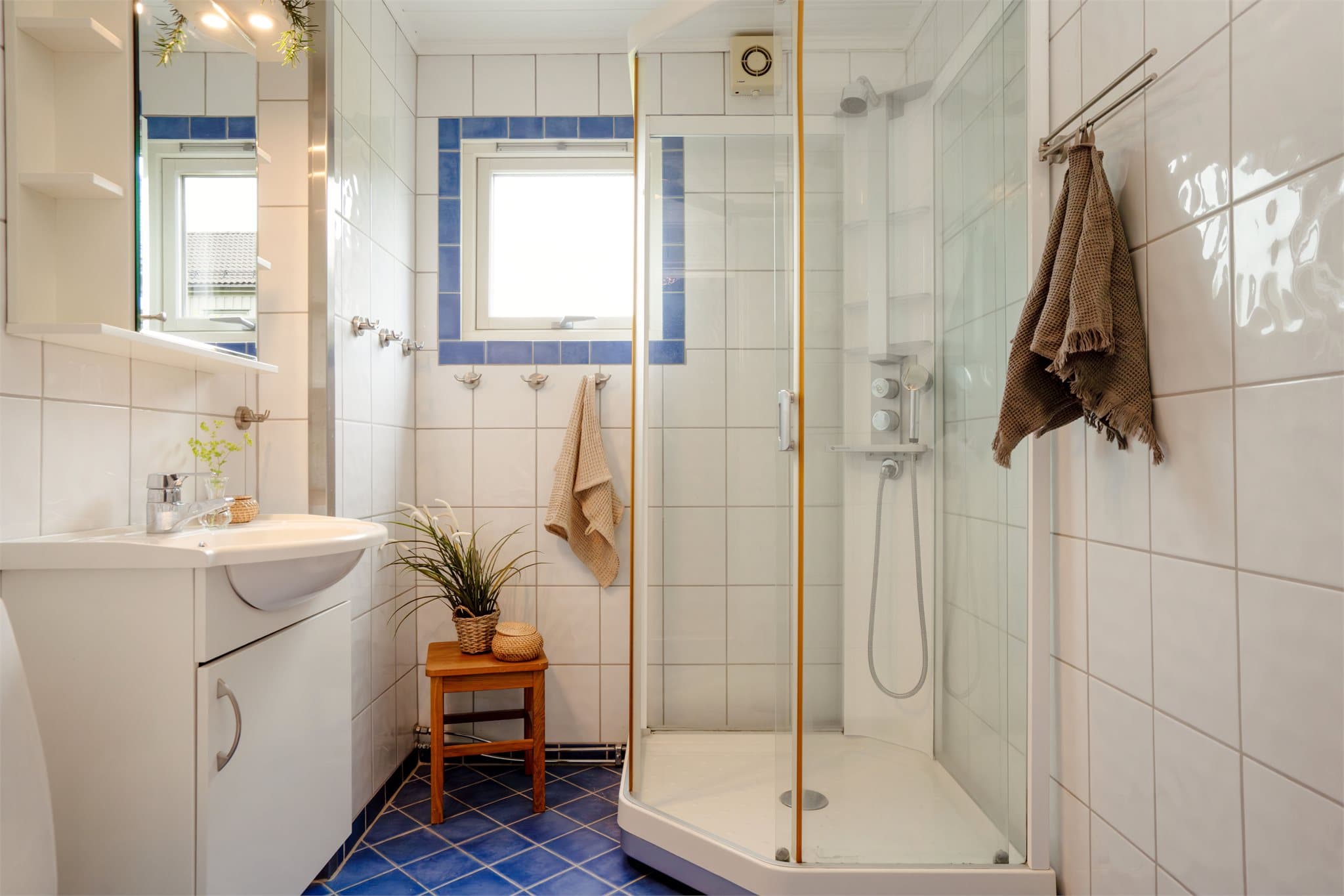 Badet er flislagt og har elektriske varmekabler i gulvet for god komfort.