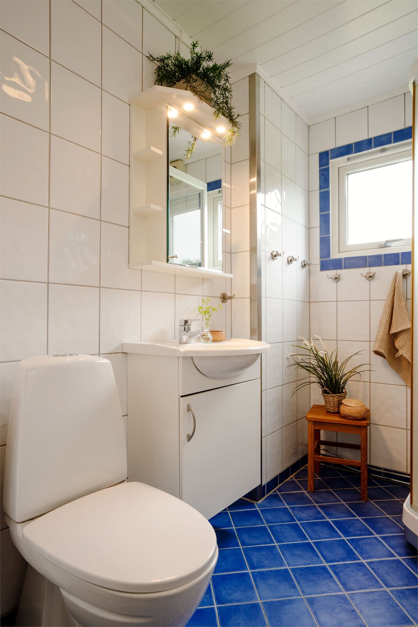 Innredet med servant, toalett og dusjkabinett. Elektrisk vifte for ventilasjon.