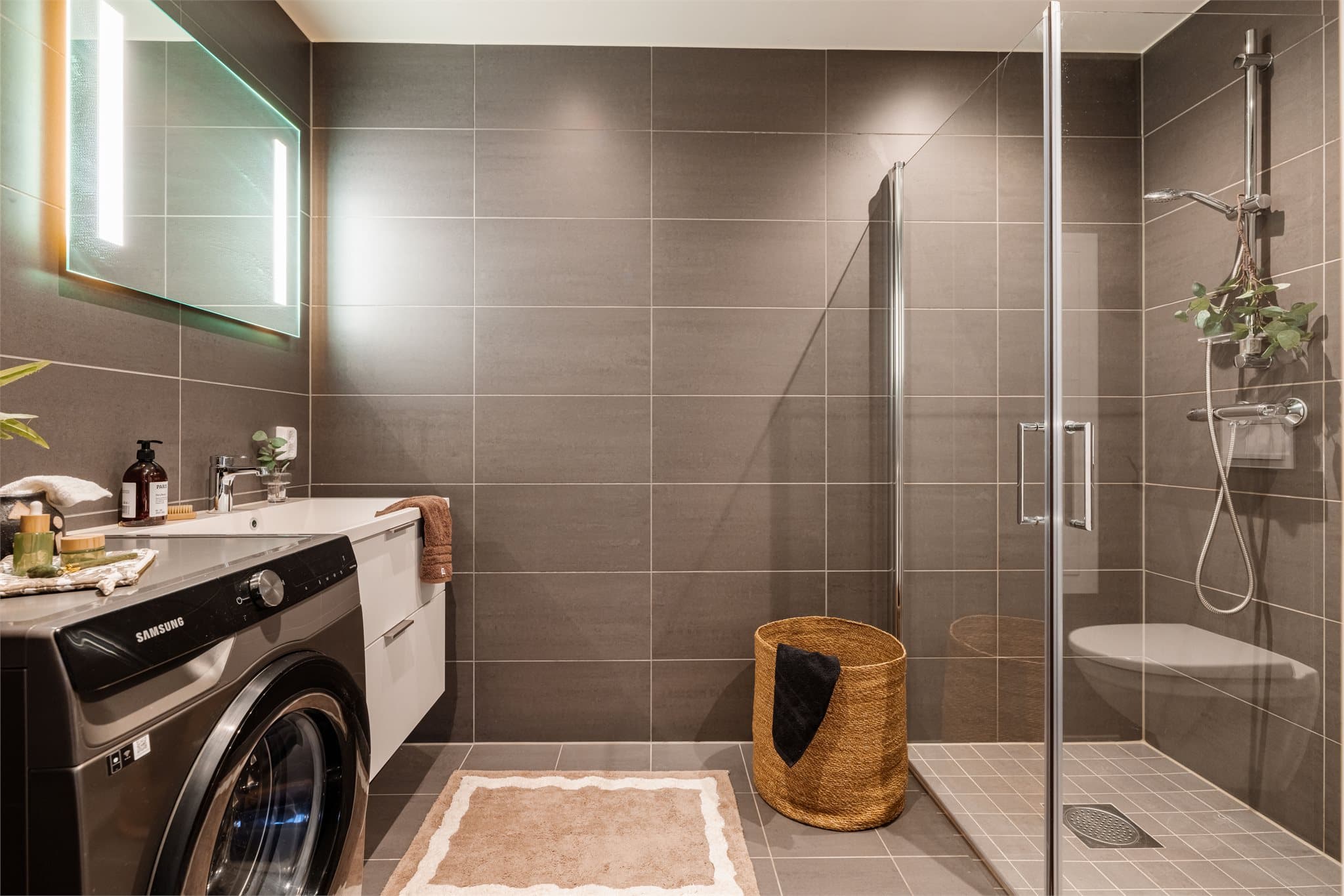 Moderne og helfliset bad med grå 30x60 fliser på vegg og 15x15 fliser på gulv.