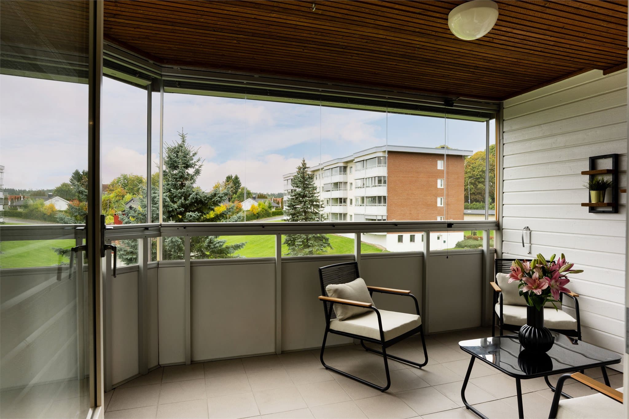 Innglasset balkong med rekkverk av aluminium og fasadeplater, samt skyvefelt i glass.