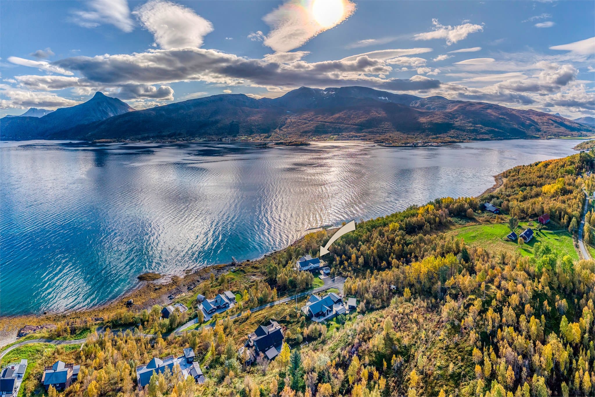 Fjordlandskap med mektige fjell som reiser seg i bakgrunnen.