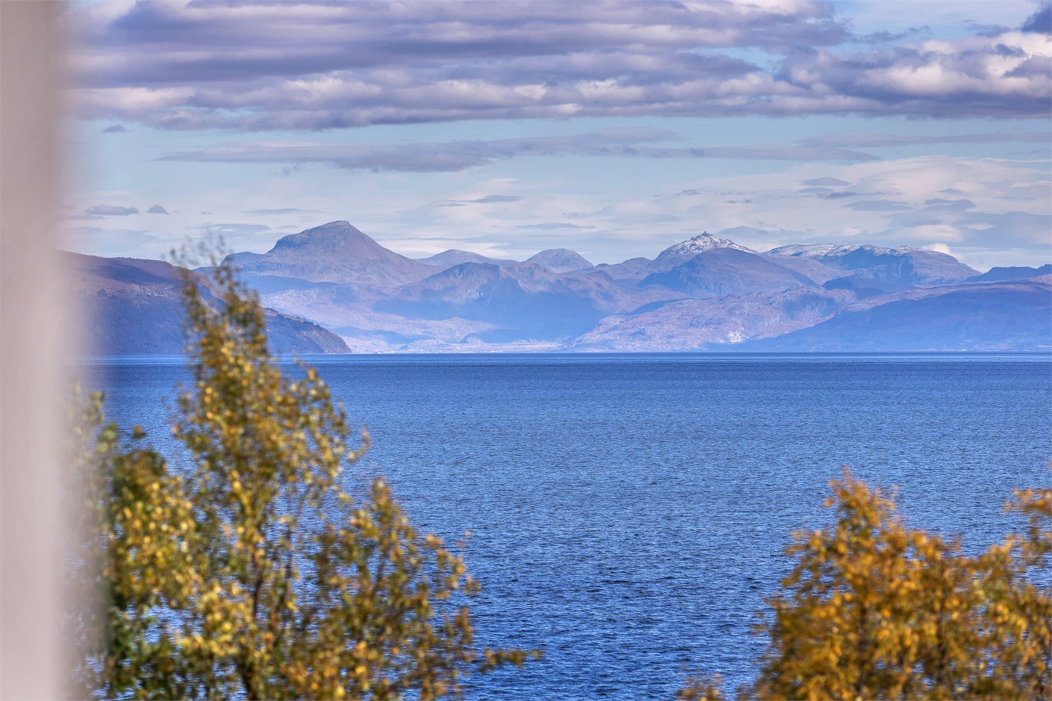 Utsikt over det åpne fjordbassenget og fjellene i horisonten.