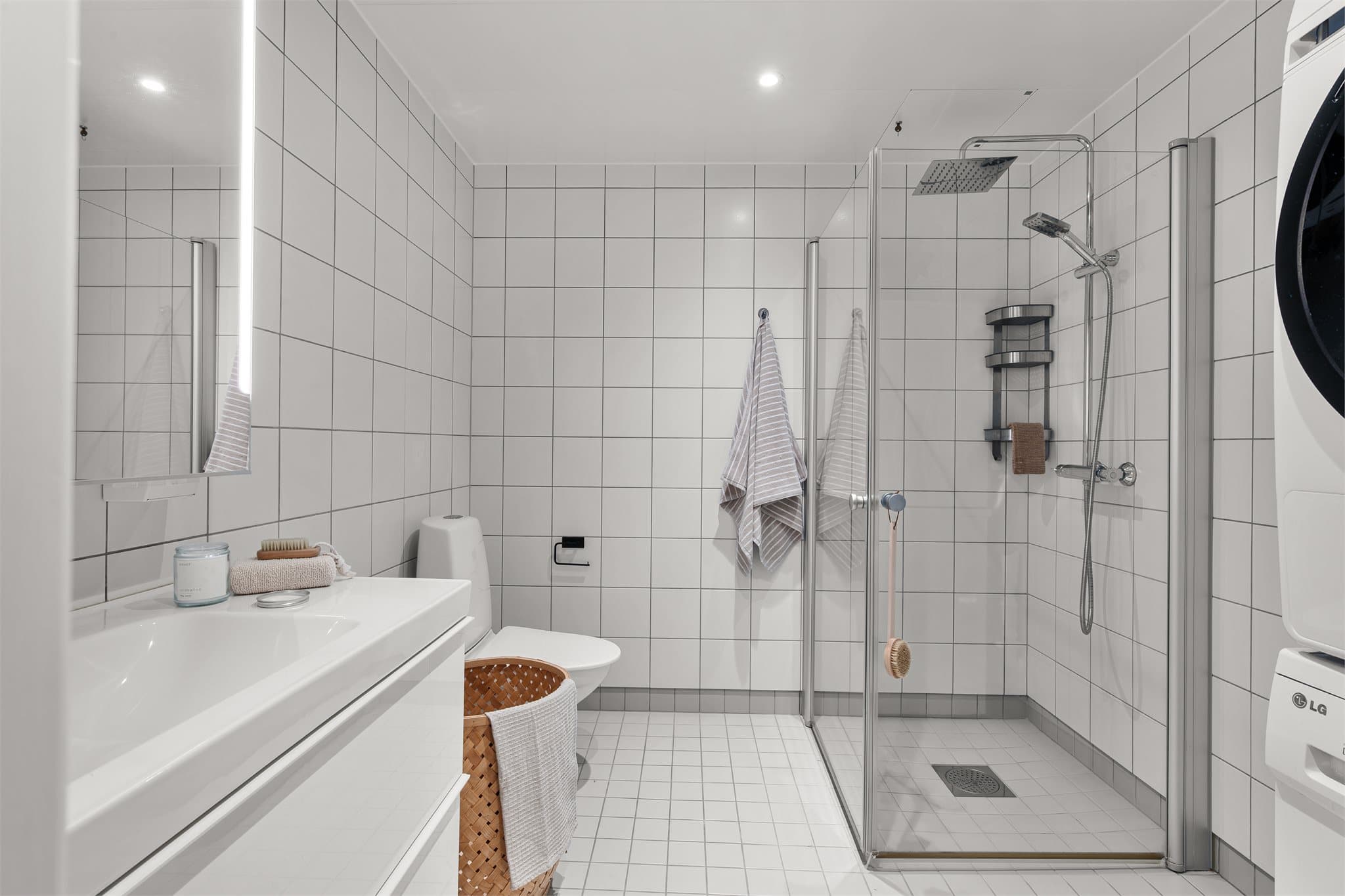 - Badet er innredet med heldekkende servant, vegghengt toalett, dusjdører i glass og opplegg for vaskemaskin -