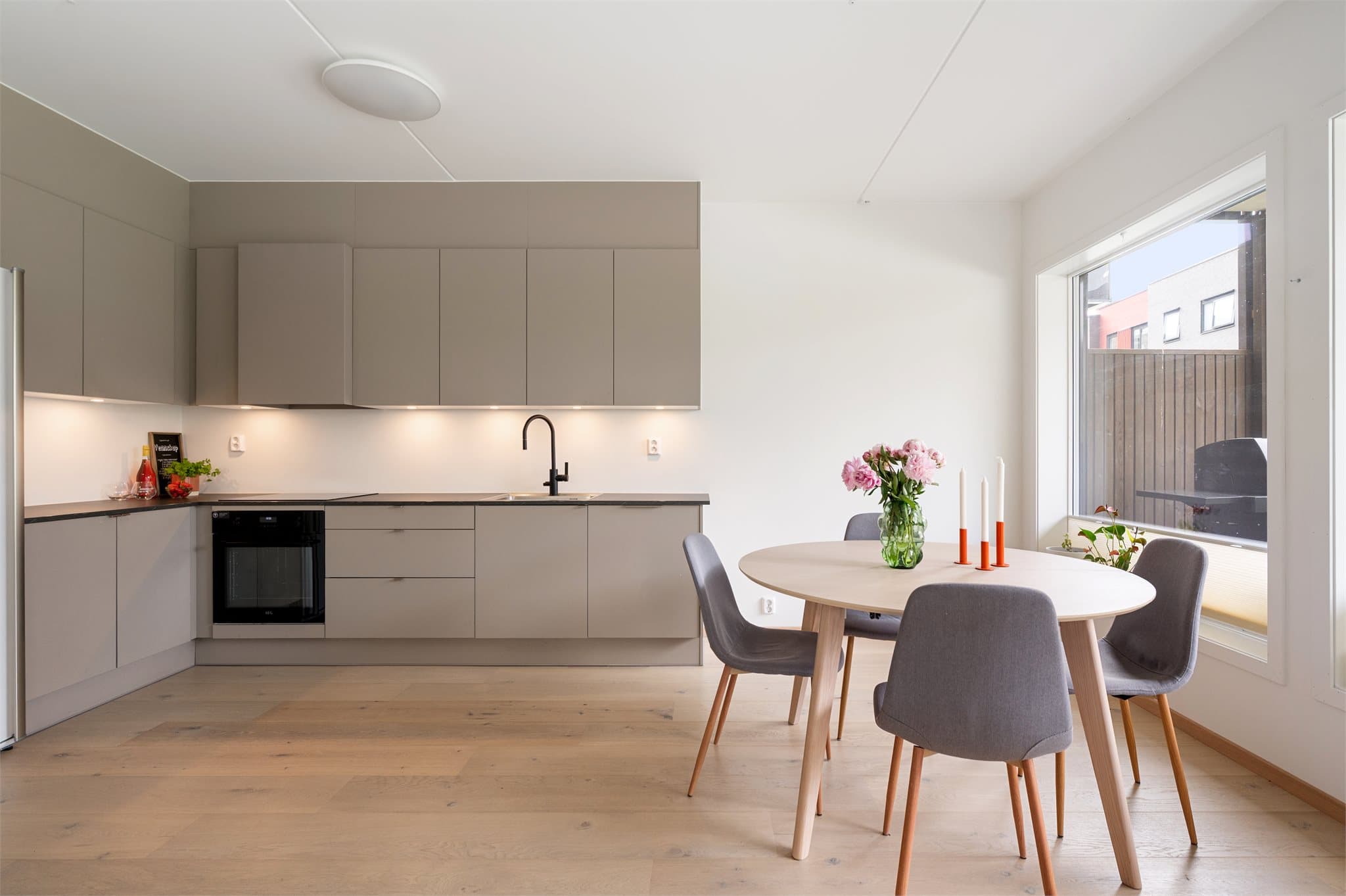 Lekker kjøkkeninnredning med glatte skapfronter, laminat benkeplater og integrerte hvitevarer.