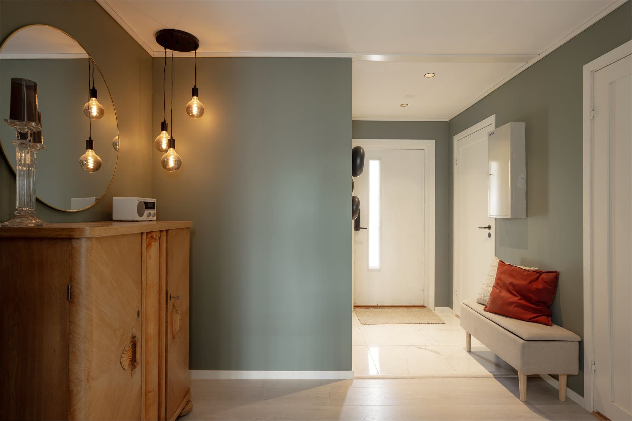 Entré med flislagt gulv med varmekabler og innfelte downlights fra 2022.