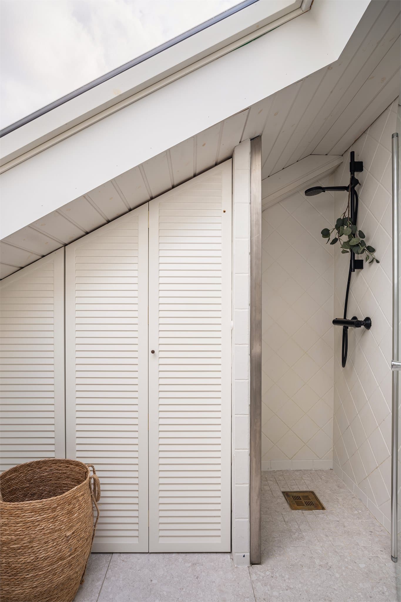 Praktisk bad med dusj i hjørnet og gjennomtenkt oppbevaring skjult bak skapdører.