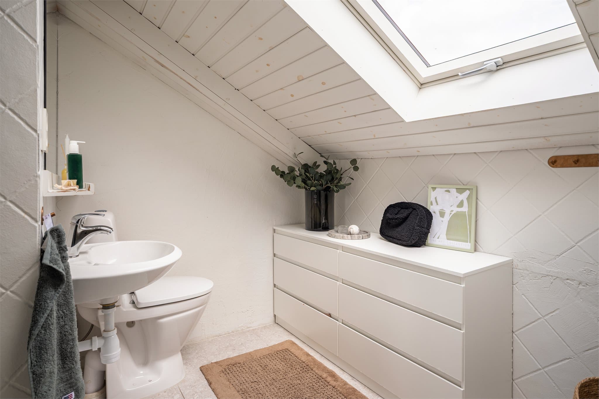 Her får du et stort bad med flott lysinnslipp og praktiske oppbevaringsløsninger.