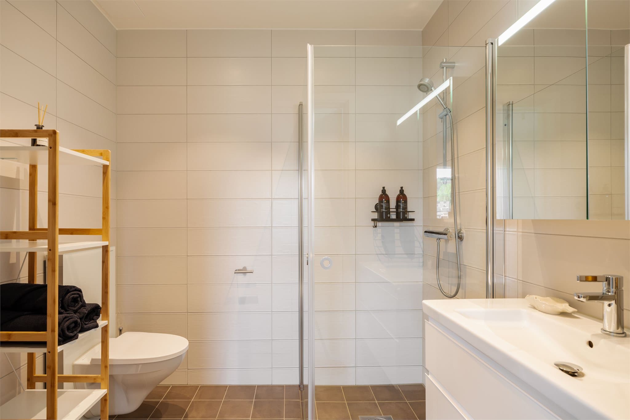 Flislagt baderom med vannbåren gulvvarme og downlights i himlingen.
