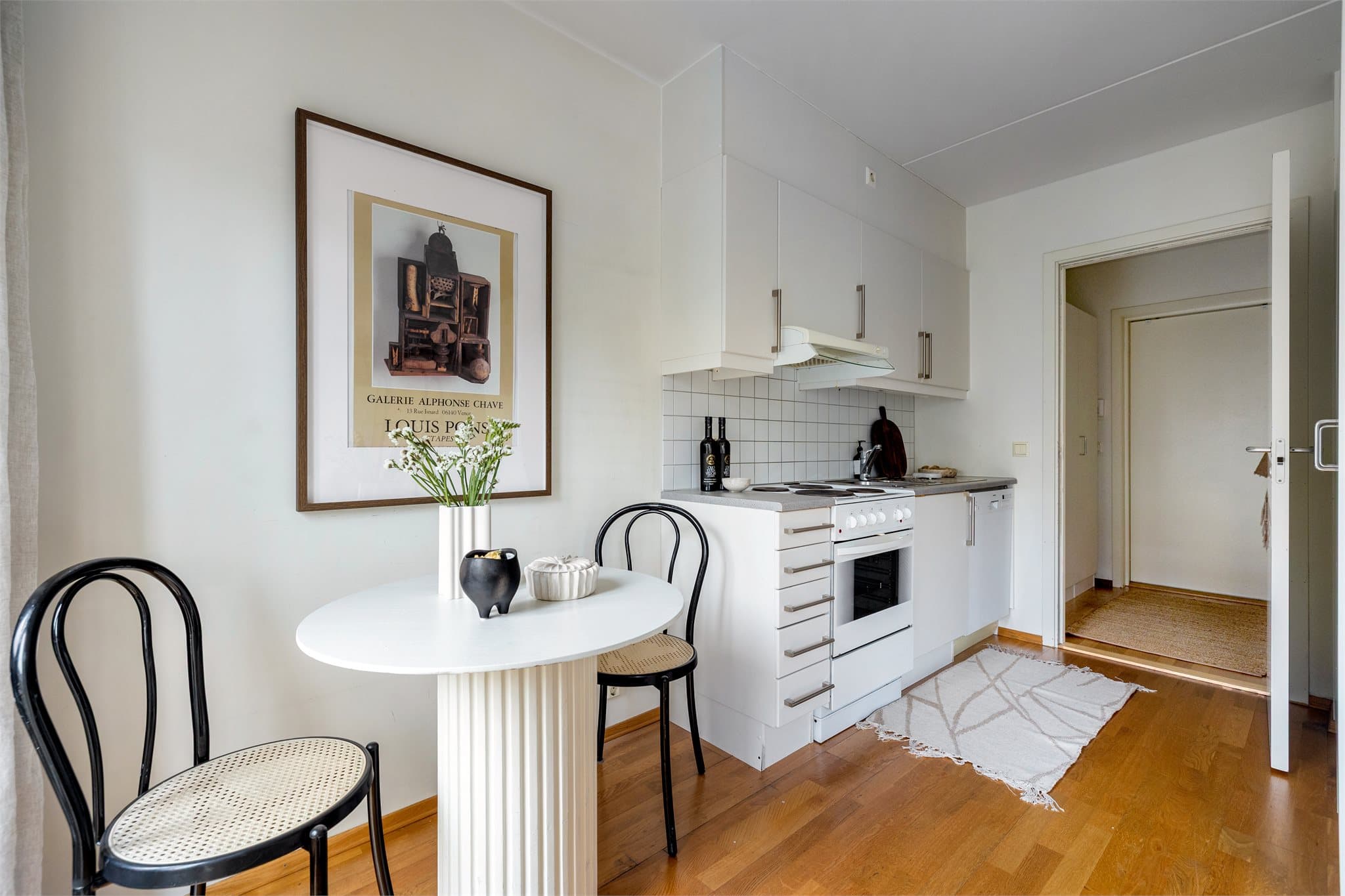 Kjøkkenet har en praktisk utforming med glatte, folierte fronter og fliser over laminatbenken.