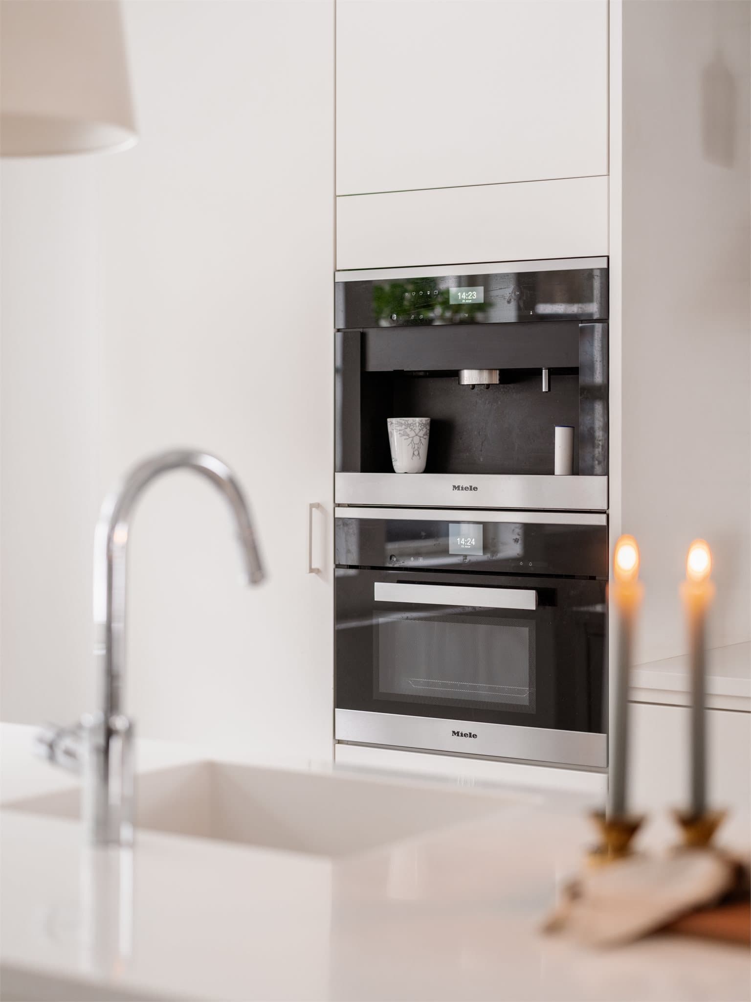 Kjøkkenet er utstyrt med integrerte hvitevarer fra Miele, inkludert kaffemaskin og kombiovn.