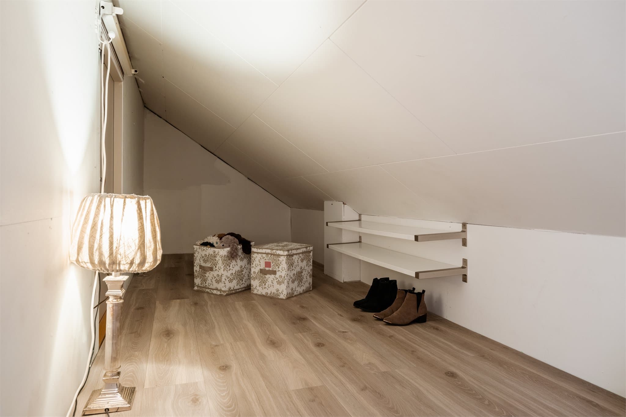 Praktiske kneloft på begge sider av loftet gir gode lagringsmuligheter.