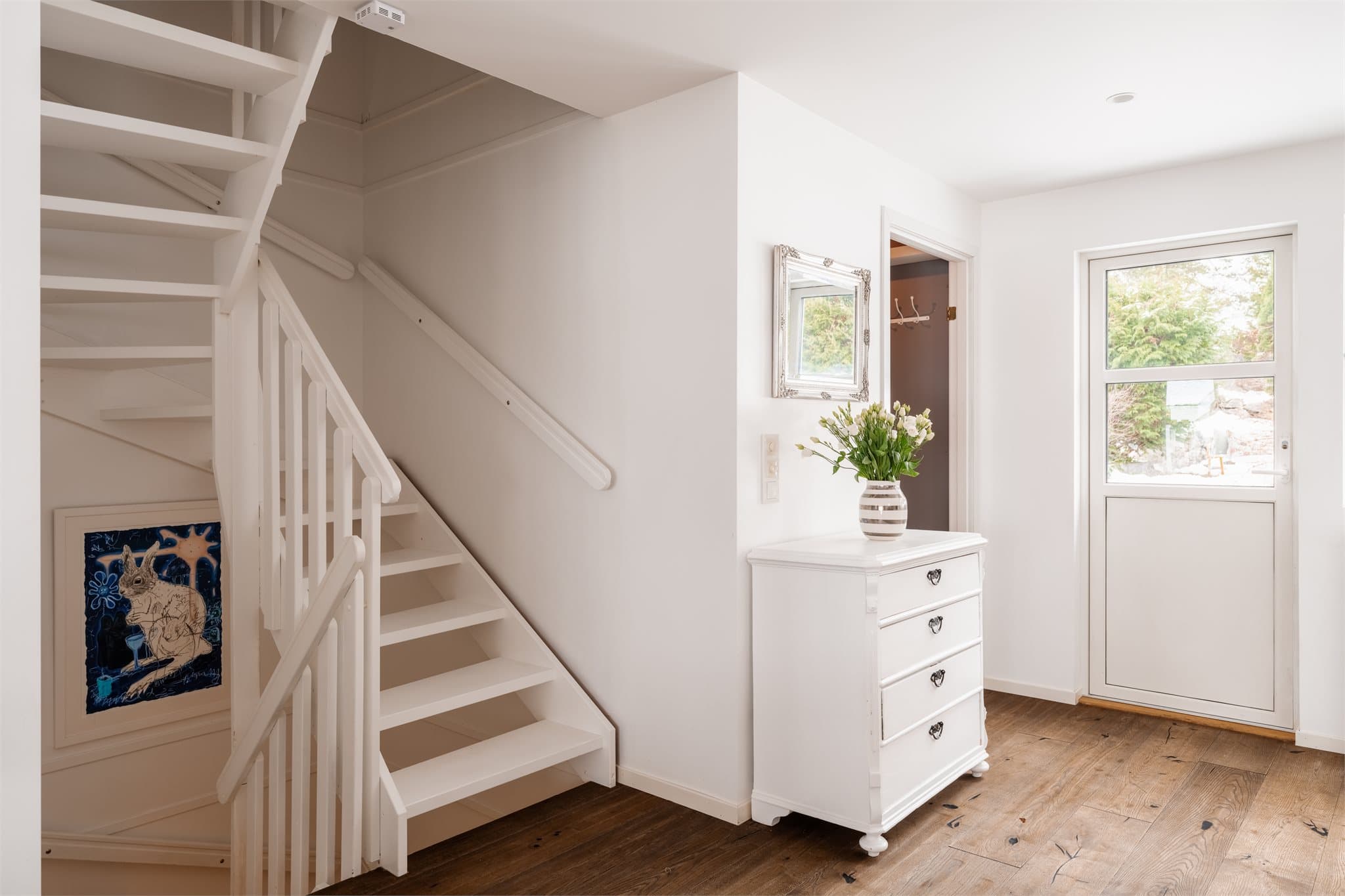 Her kommer du opp til en lys og åpen etasje med gjennomgående parkettgulv.